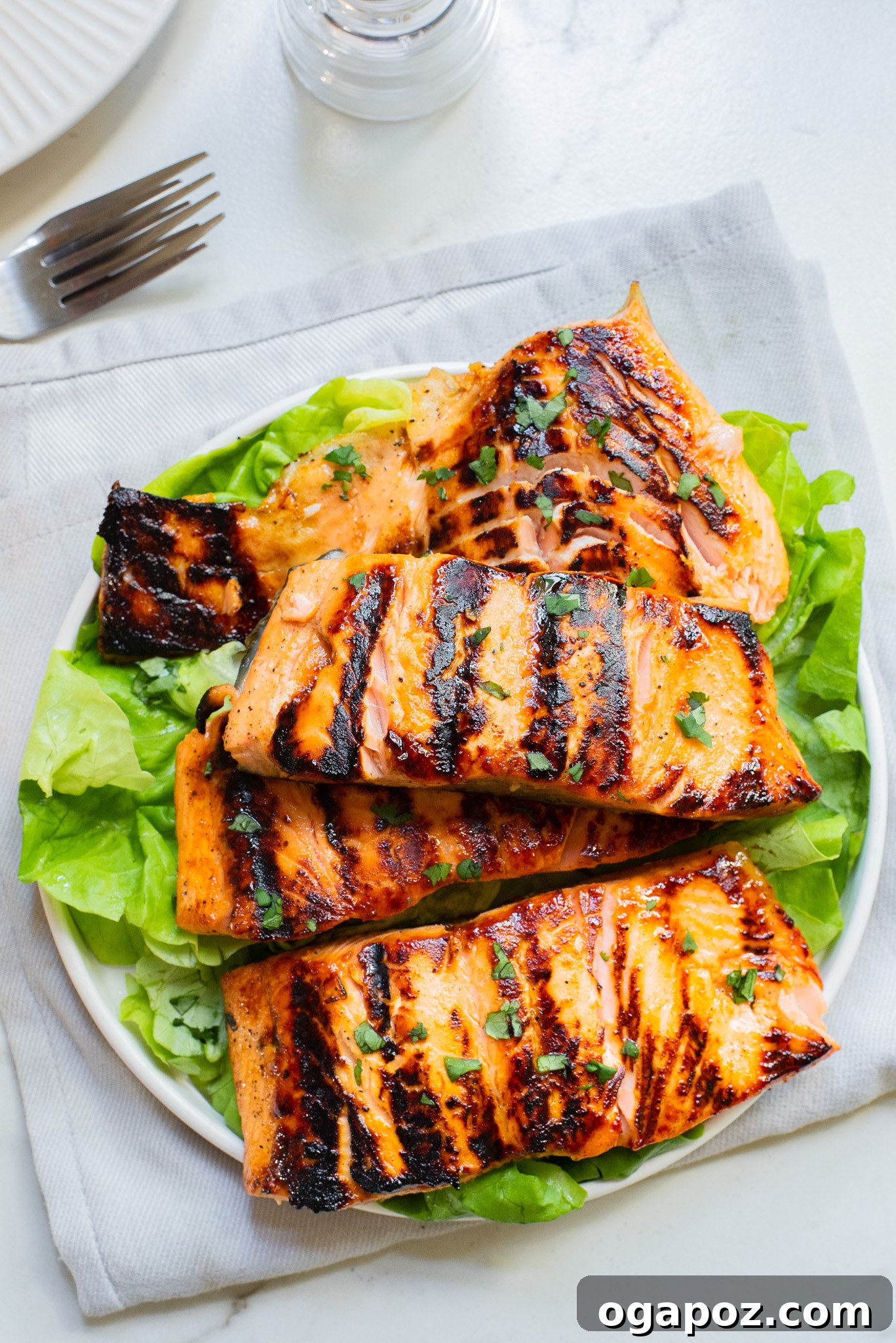 A cooked Honey Mustard Salmon fillet resting on a bed of fresh lettuce leaves, ready to be served.