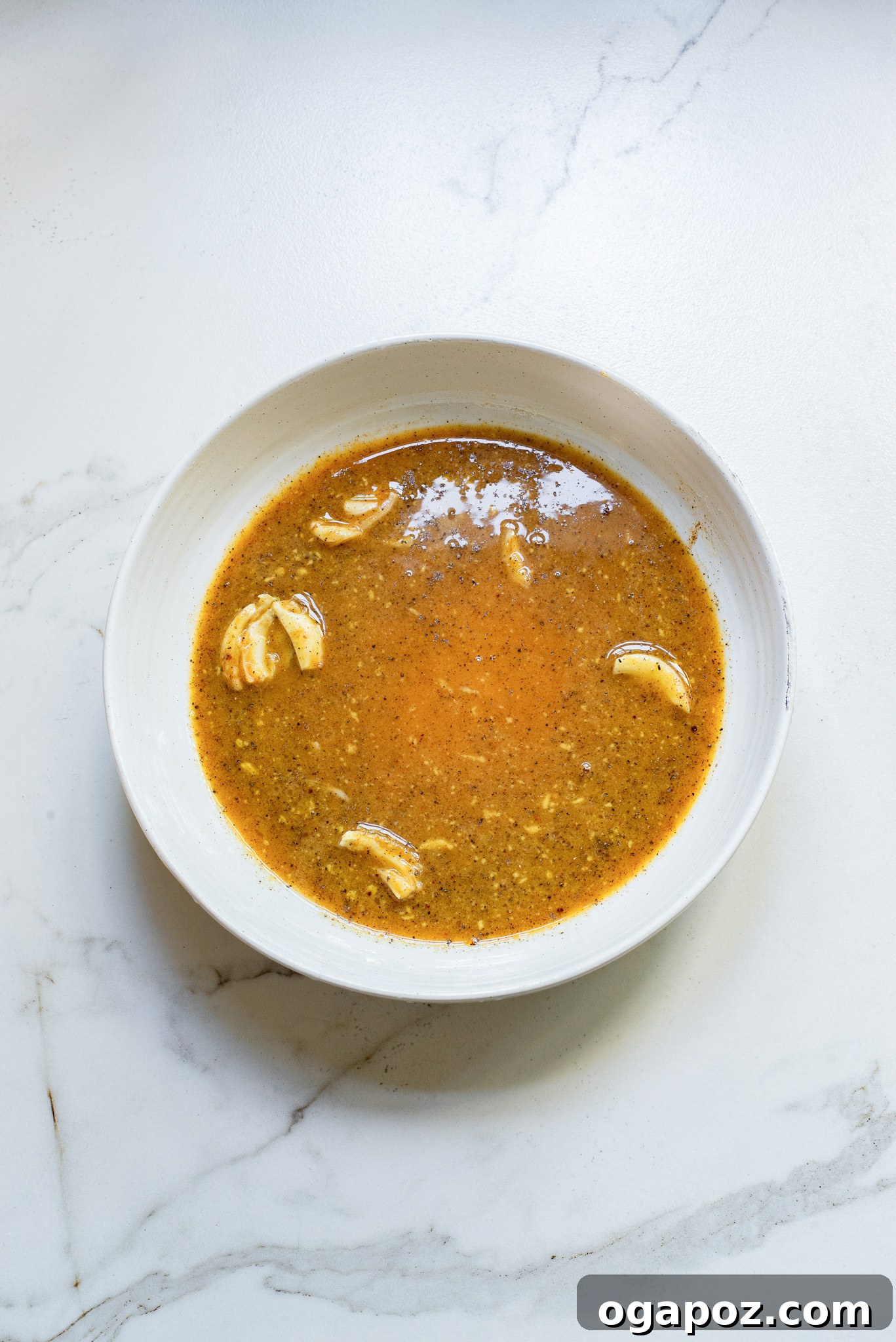 A small bowl containing the freshly mixed honey mustard marinade, showcasing its creamy texture.