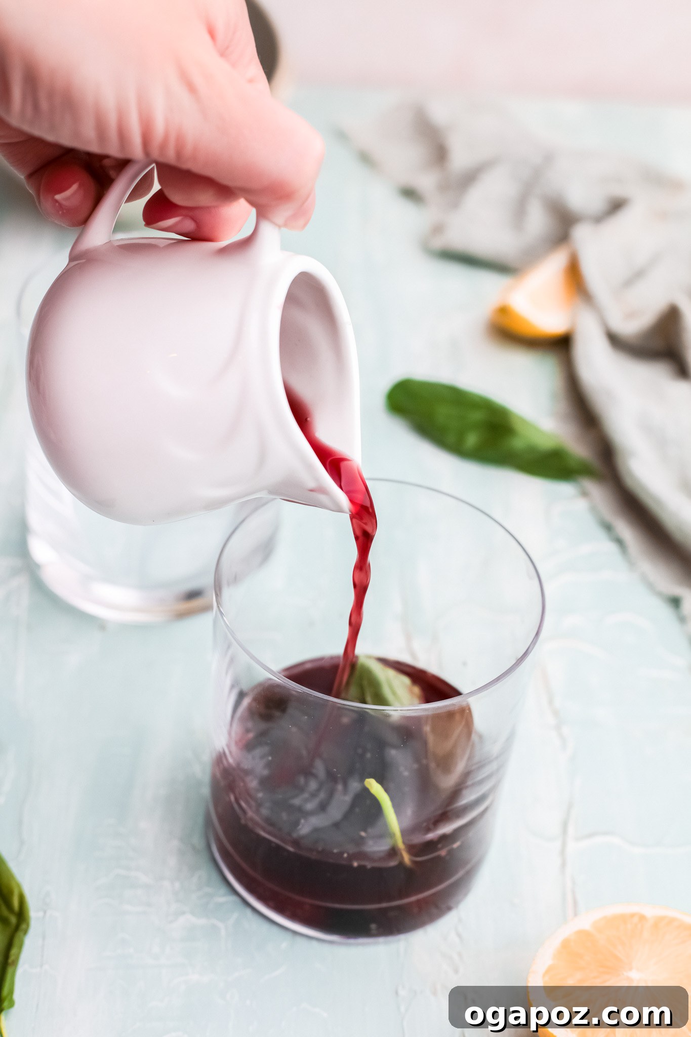 Spiked Cherry Lime Delight 6 Pouring bright red cherry juice into a glass with other cocktail ingredients, illustrating a step in the recipe.