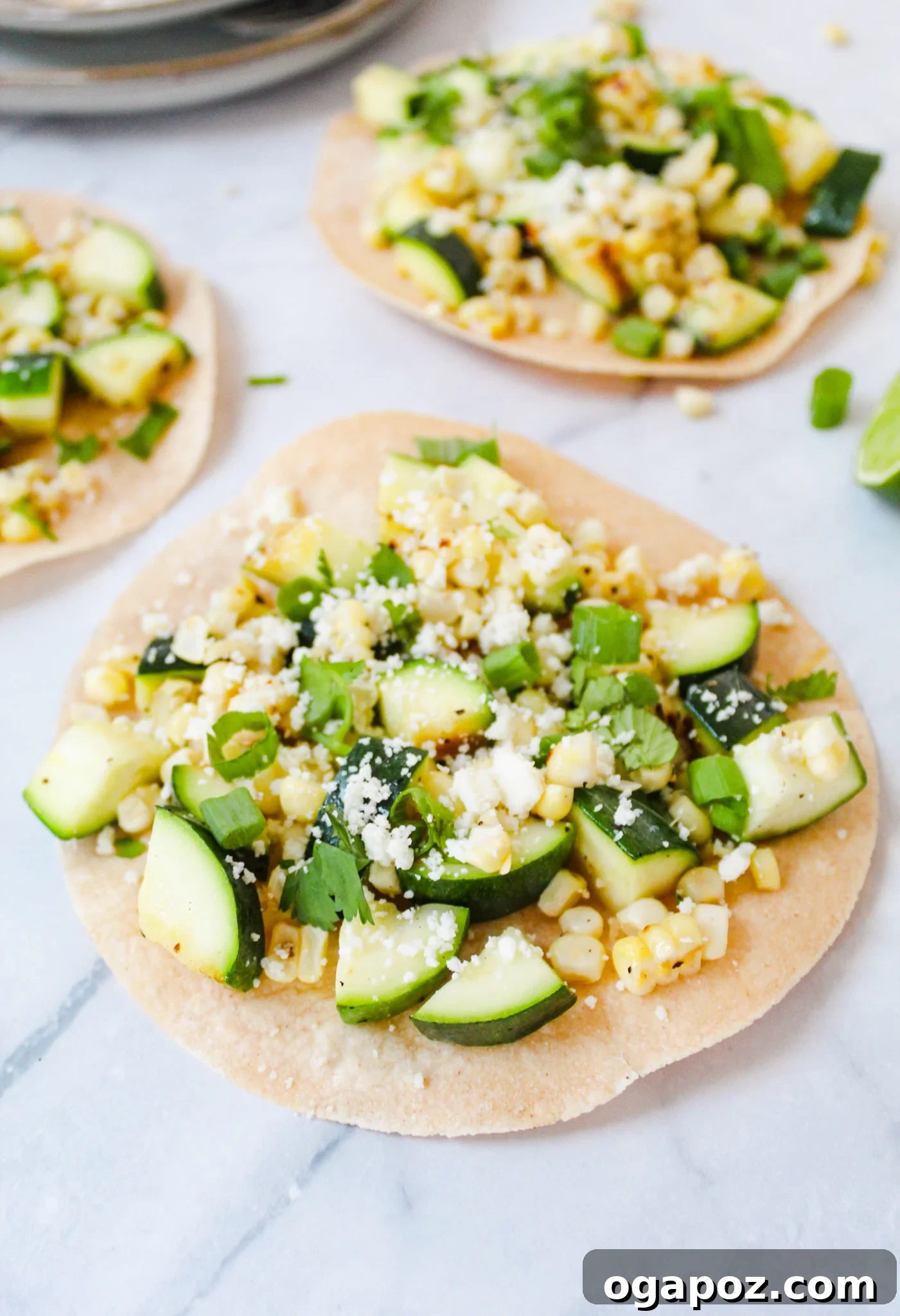 Effortless Zucchini Tacos 2 Easy Zucchini Tacos arranged on a marble background with fresh ingredients.