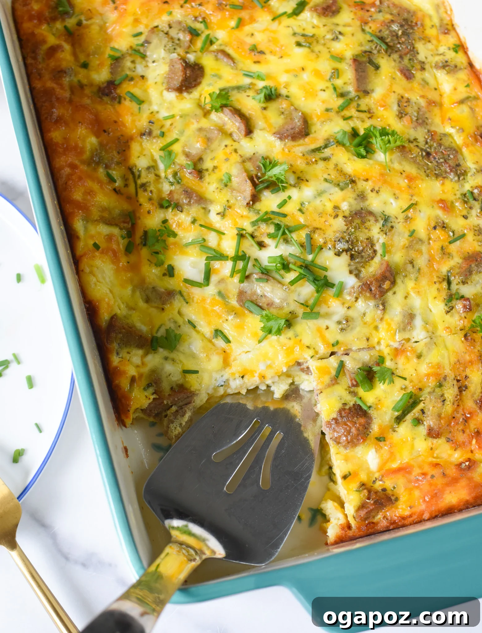Savory Cottage Cheese Egg Bake 2 A large casserole dish filled with golden brown Cheese and Sausage Baked Eggs, garnished with fresh herbs, ready for serving.