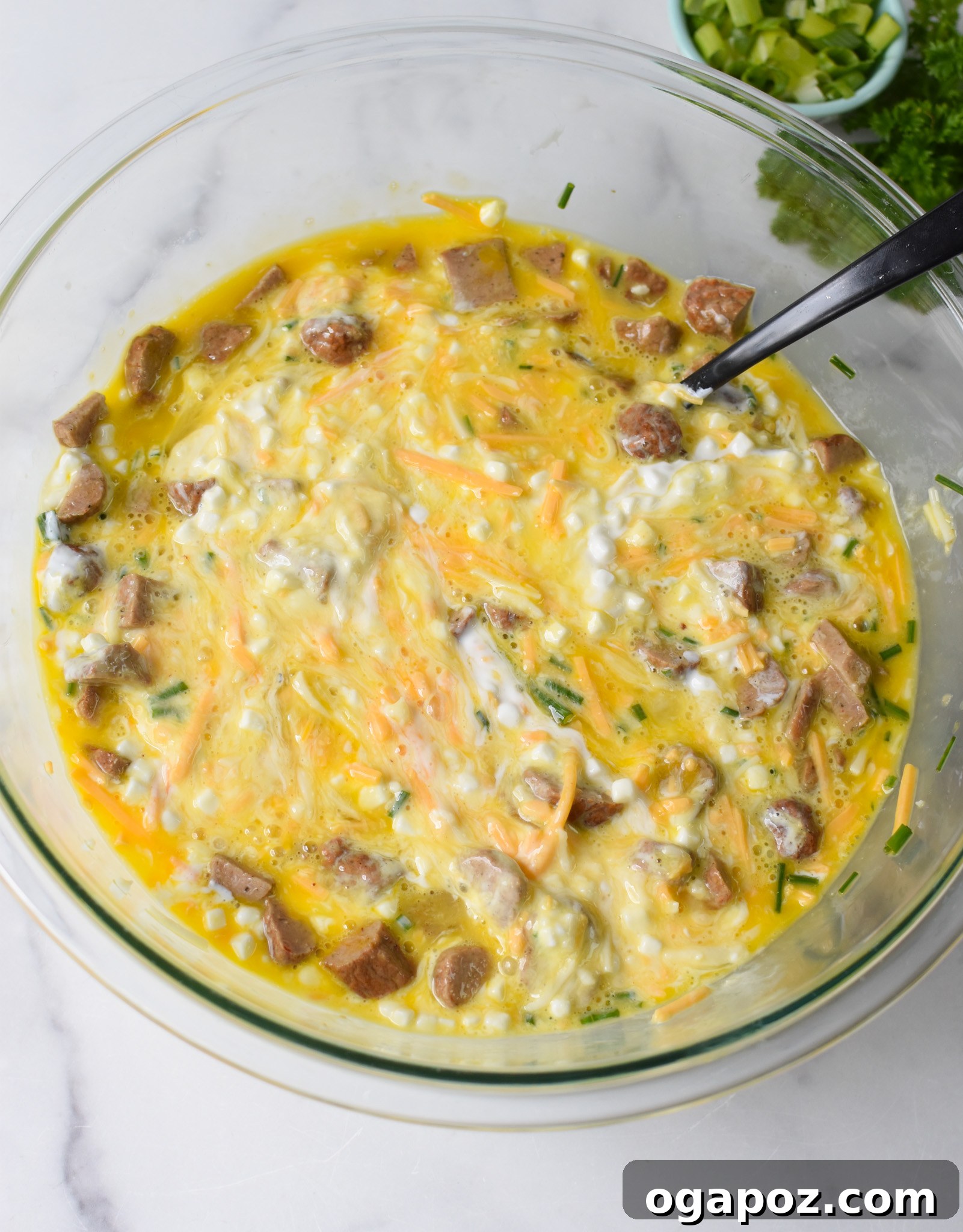 Savory Cottage Cheese Egg Bake 7 The Cottage Cheese Baked Eggs mixture, now fully combined, clearly showing the even distribution of cheese, sausage, and herbs throughout the egg base.