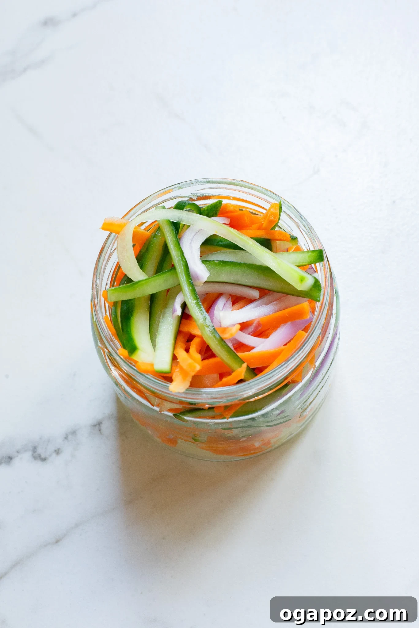 Fresh and Fast Pickles 3 Quick Pickled Vegetables beautifully arranged in a clear glass jar, showcasing their vibrant colors and crisp texture.