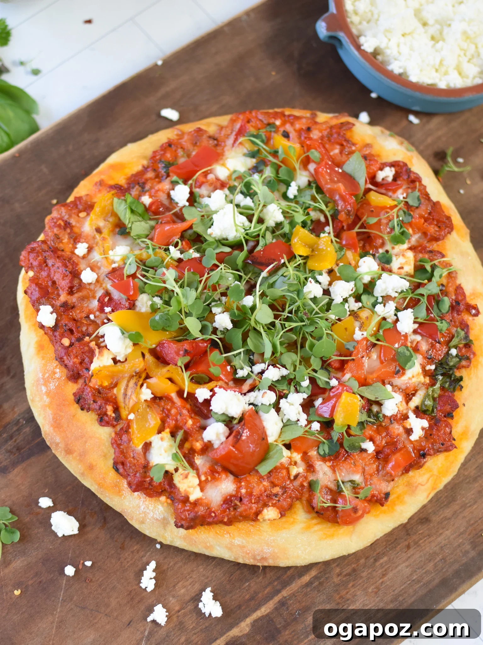 Sun-Kissed Mediterranean Skillet Pizza 2 Cast Iron Mediterranean Pizza on a cutting board, garnished with fresh herbs and a slice ready to be served.