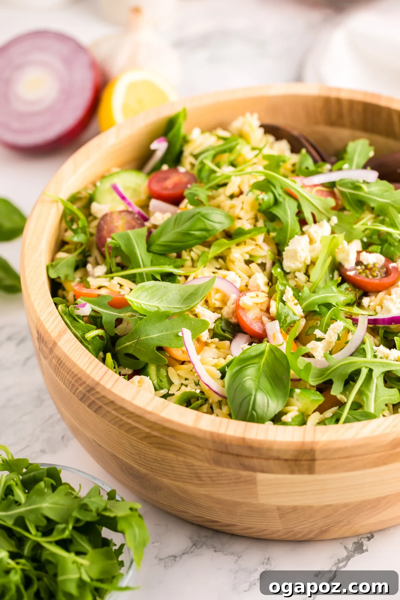 Vibrant Arugula Orzo Salad 11 Arugula Orzo Salad served in a rustic wooden bowl.