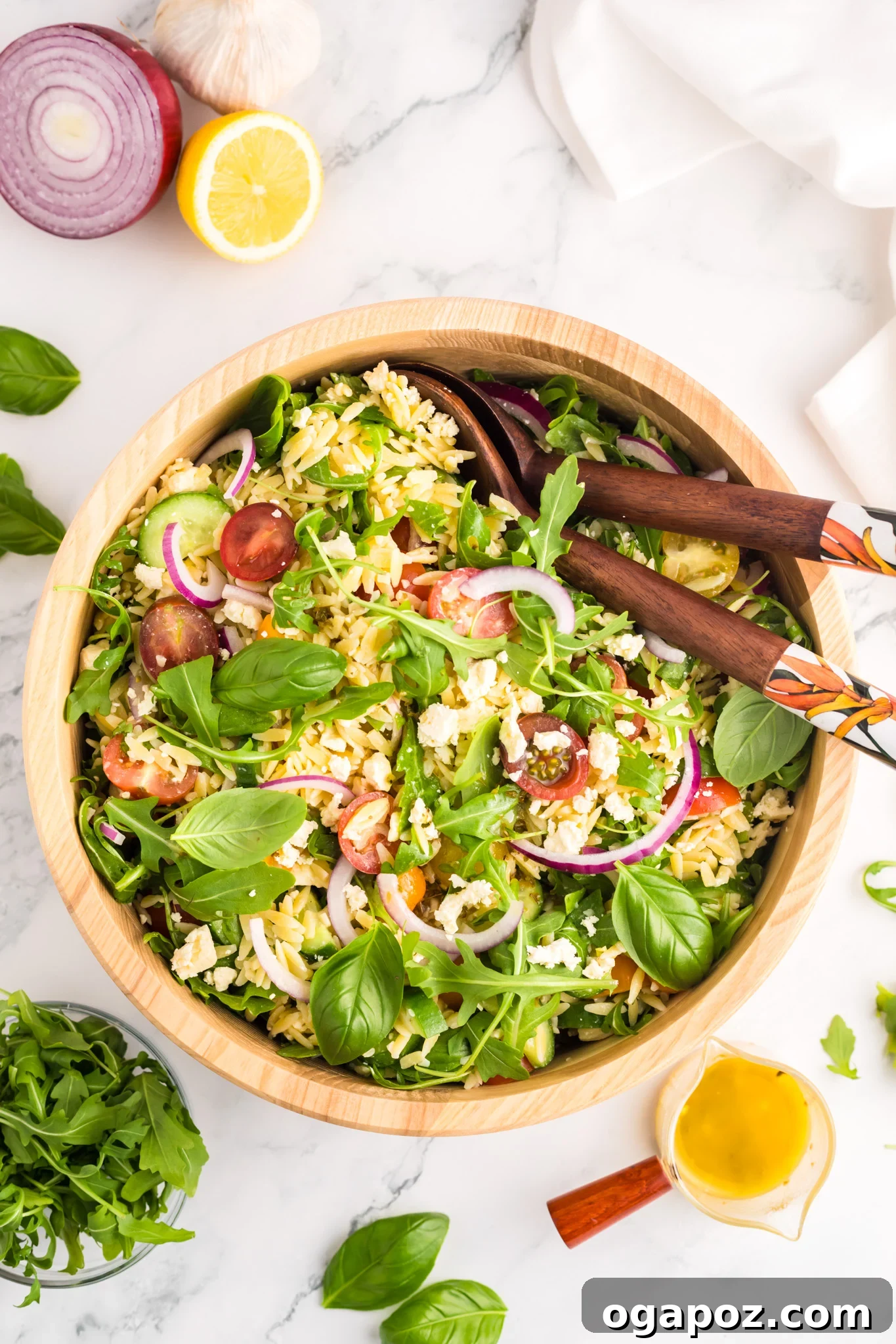 Vibrant Arugula Orzo Salad 3 Overhead shot of Arugula Orzo Salad in a white bowl, garnished with fresh herbs.