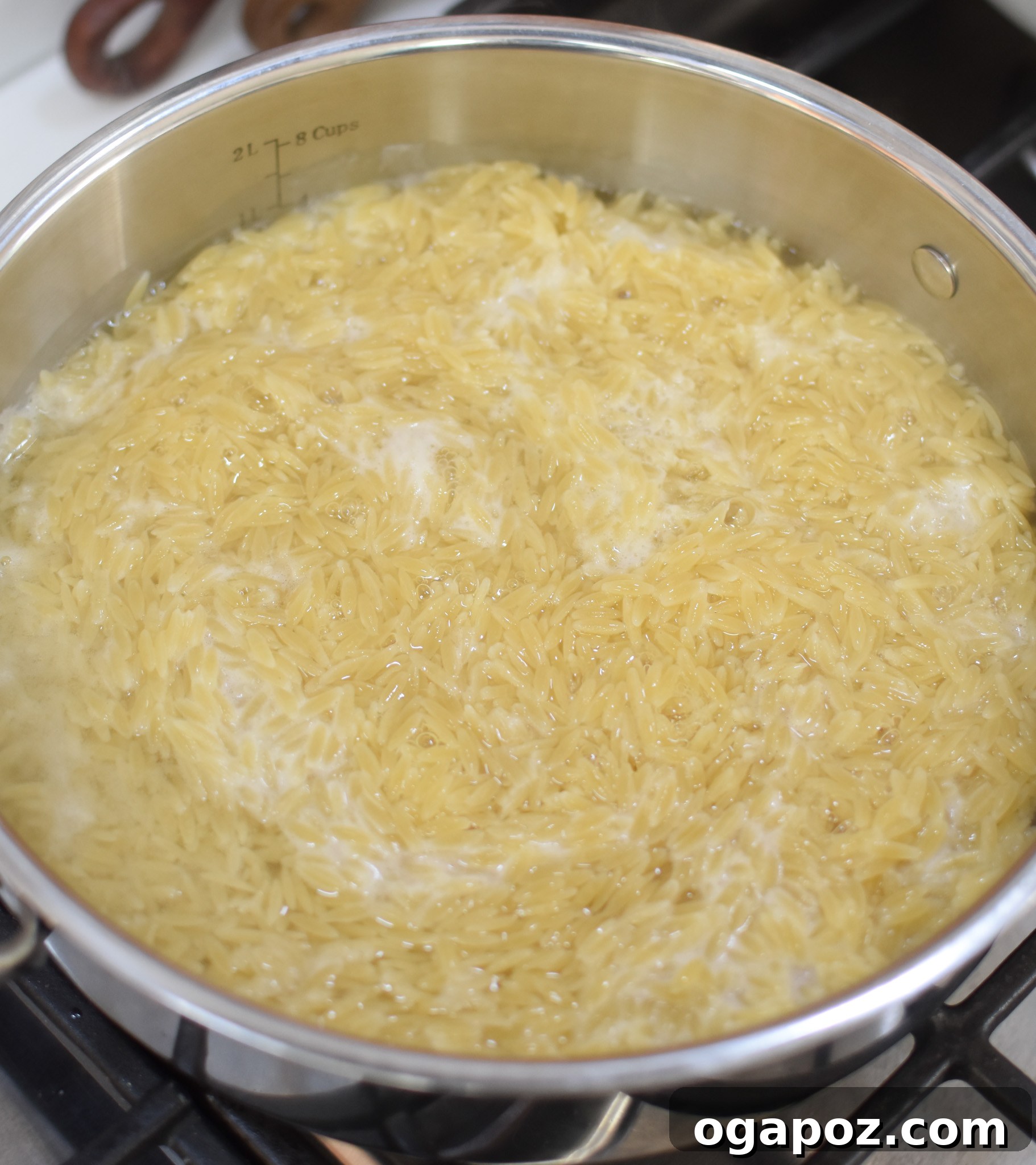Bright Lemon Chicken Orzo 8 Orzo pasta cooking in a pot with broth.