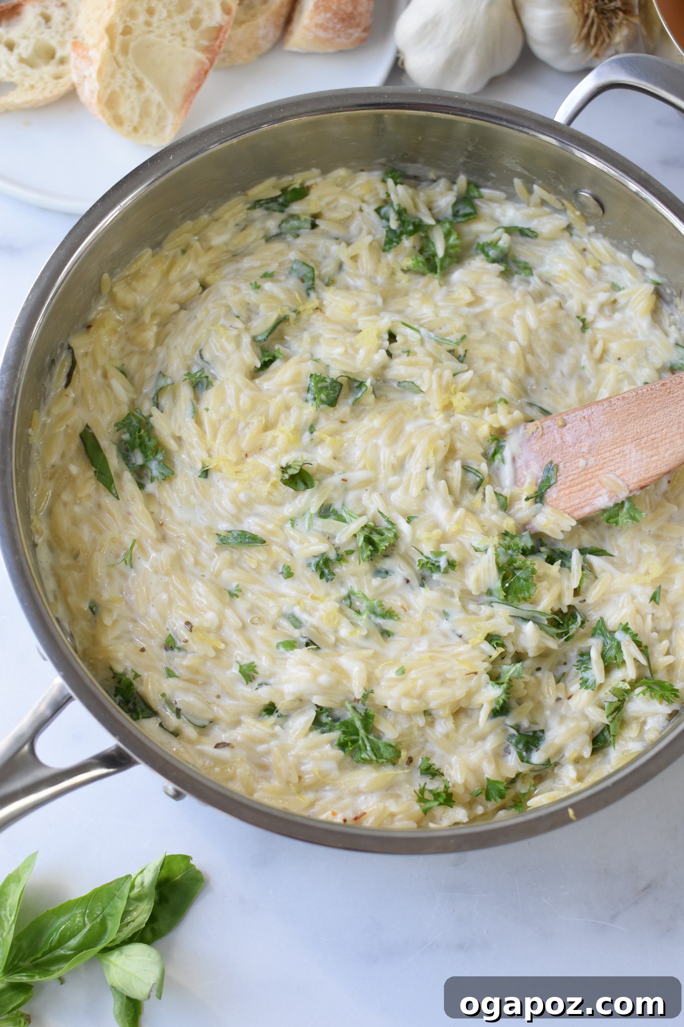 Bright Lemon Chicken Orzo 10 Lemon Chicken Orzo served in a bowl with a wooden spoon.