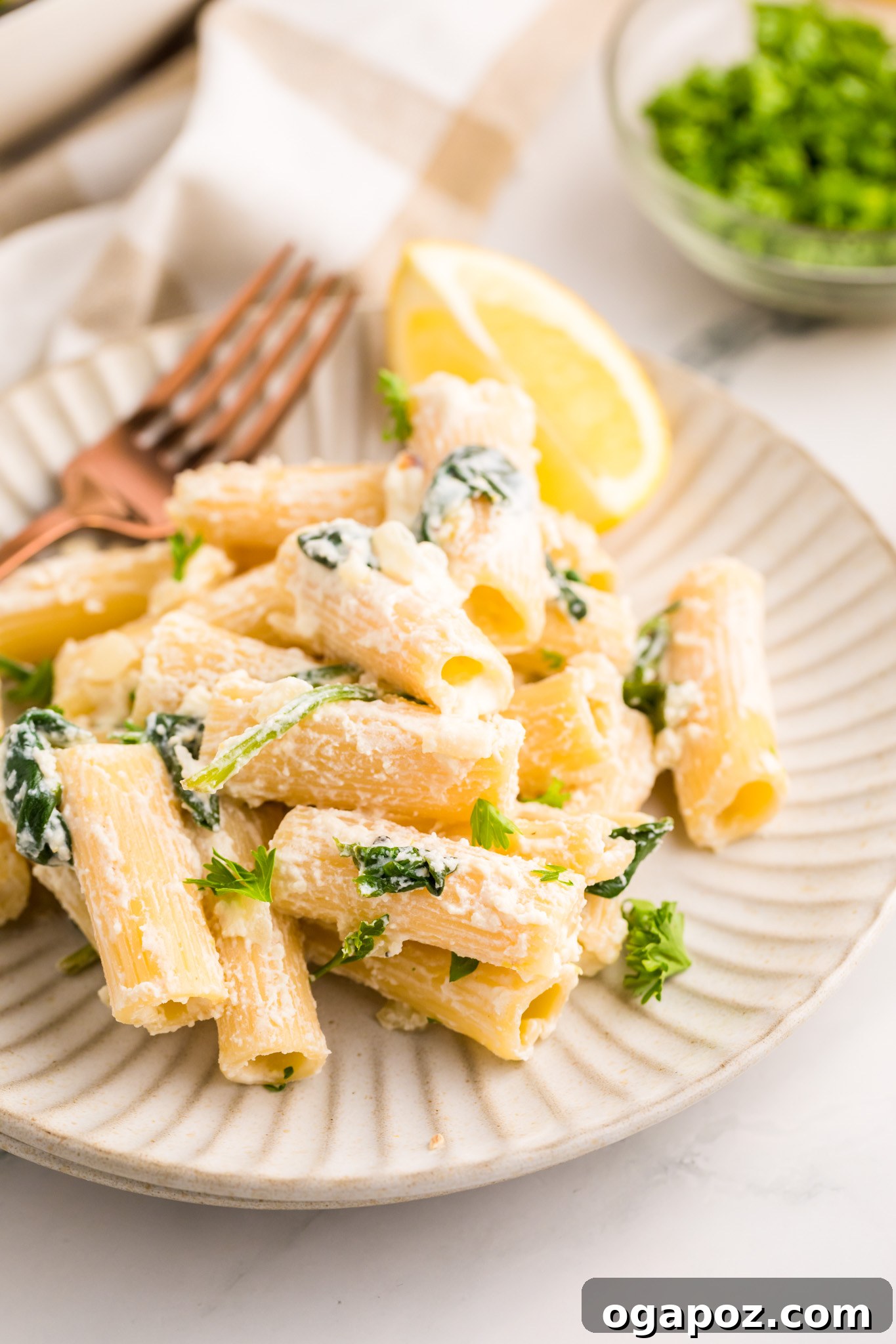 Velvety Lemon Ricotta Pasta 3 Close-up of Lemon Ricotta Pasta with a fork twirling a generous portion, highlighting its creamy sauce and flecks of green spinach.