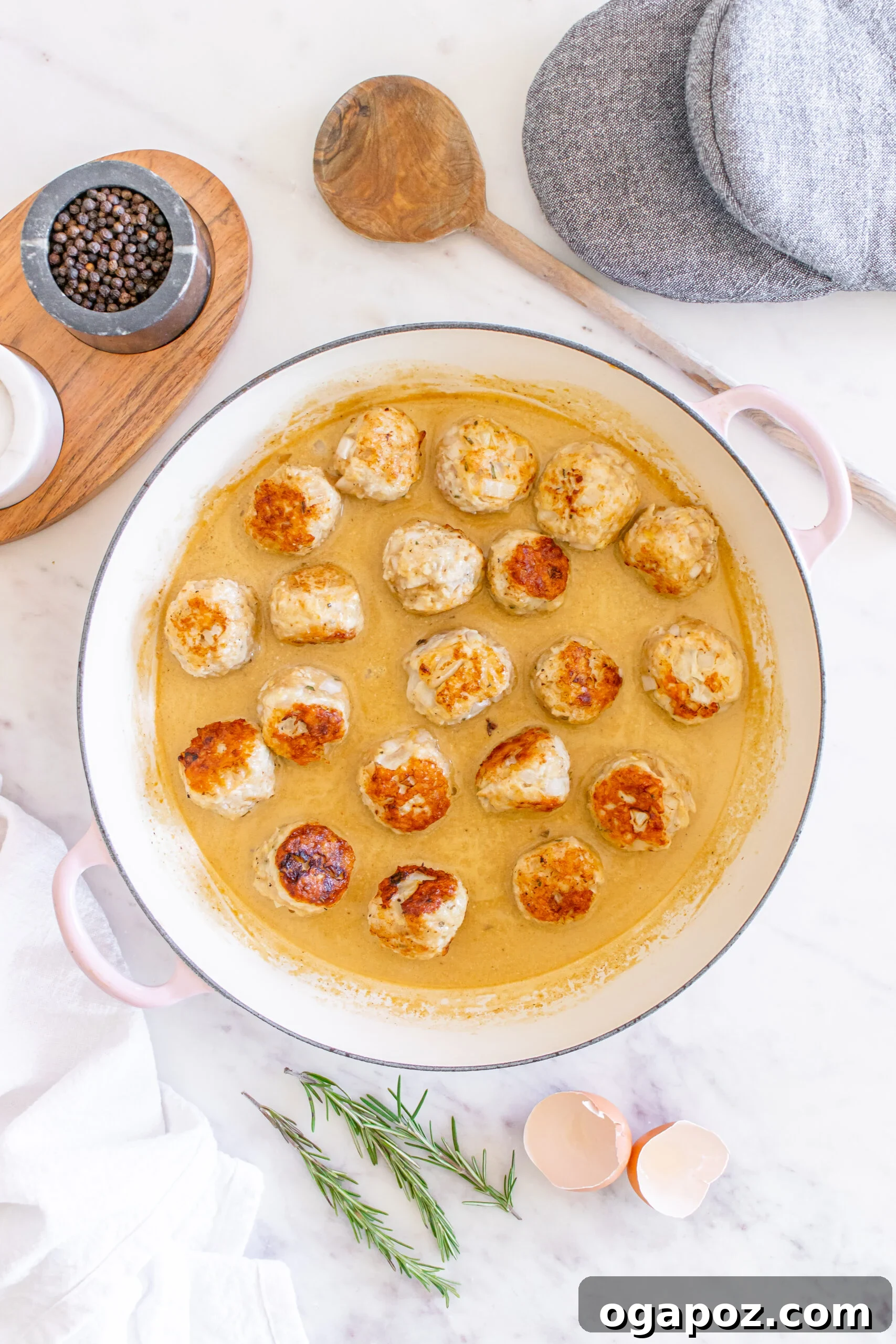 Sticky Maple Dijon Turkey Meatballs 11 Maple Dijon Turkey Meatballs gently simmering in the creamy sauce in a Dutch oven.