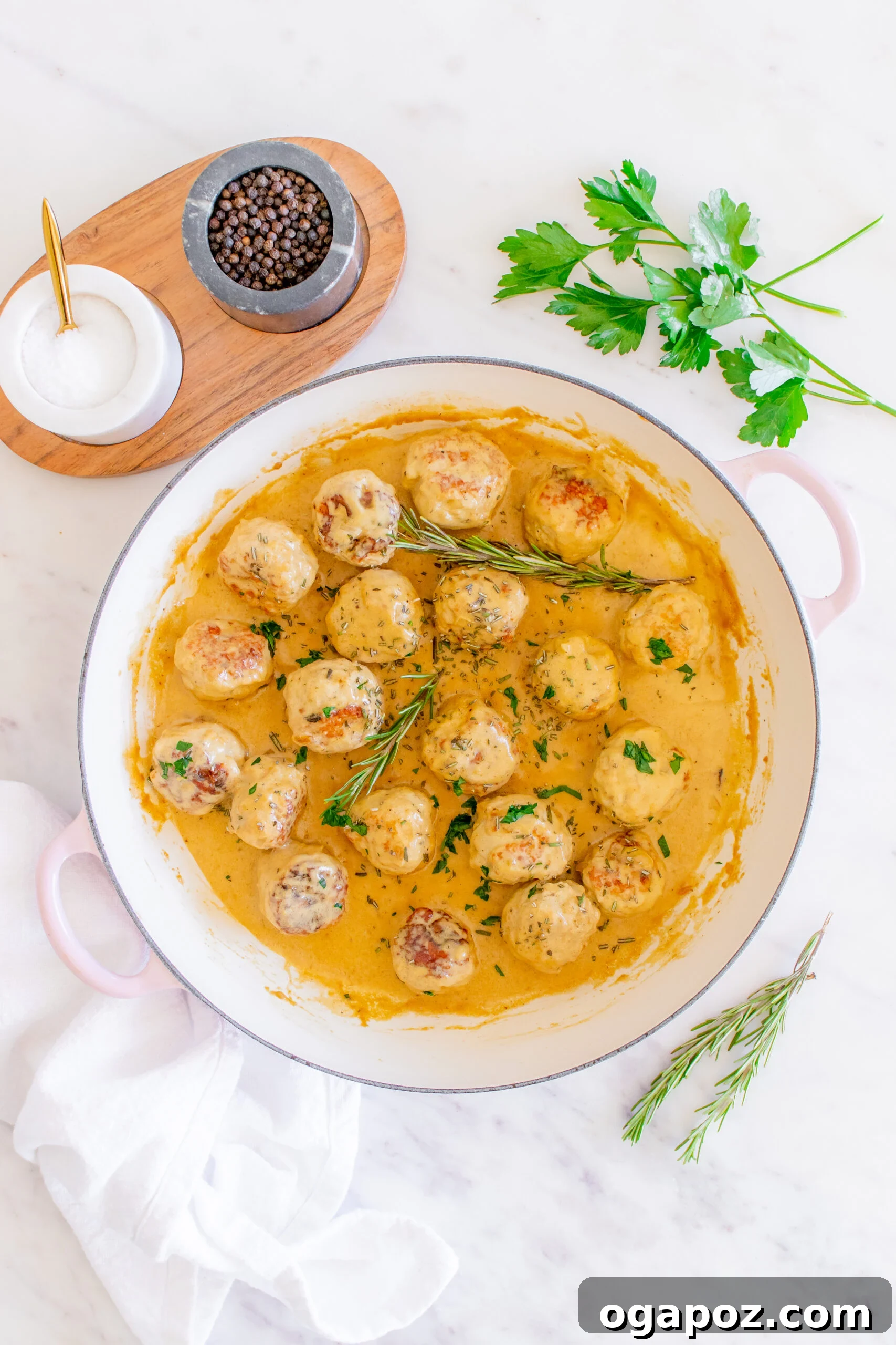 Sticky Maple Dijon Turkey Meatballs 12 Finished Maple Dijon Turkey Meatballs in a Dutch oven, garnished with fresh rosemary.