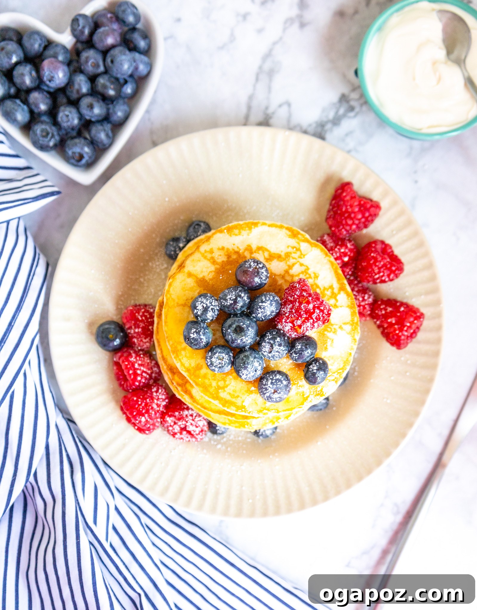 Fluffy Buttermilk Pancake Bliss 3 A stack of homemade buttermilk pancakes with fresh berries and powdered sugar, ready to be served.