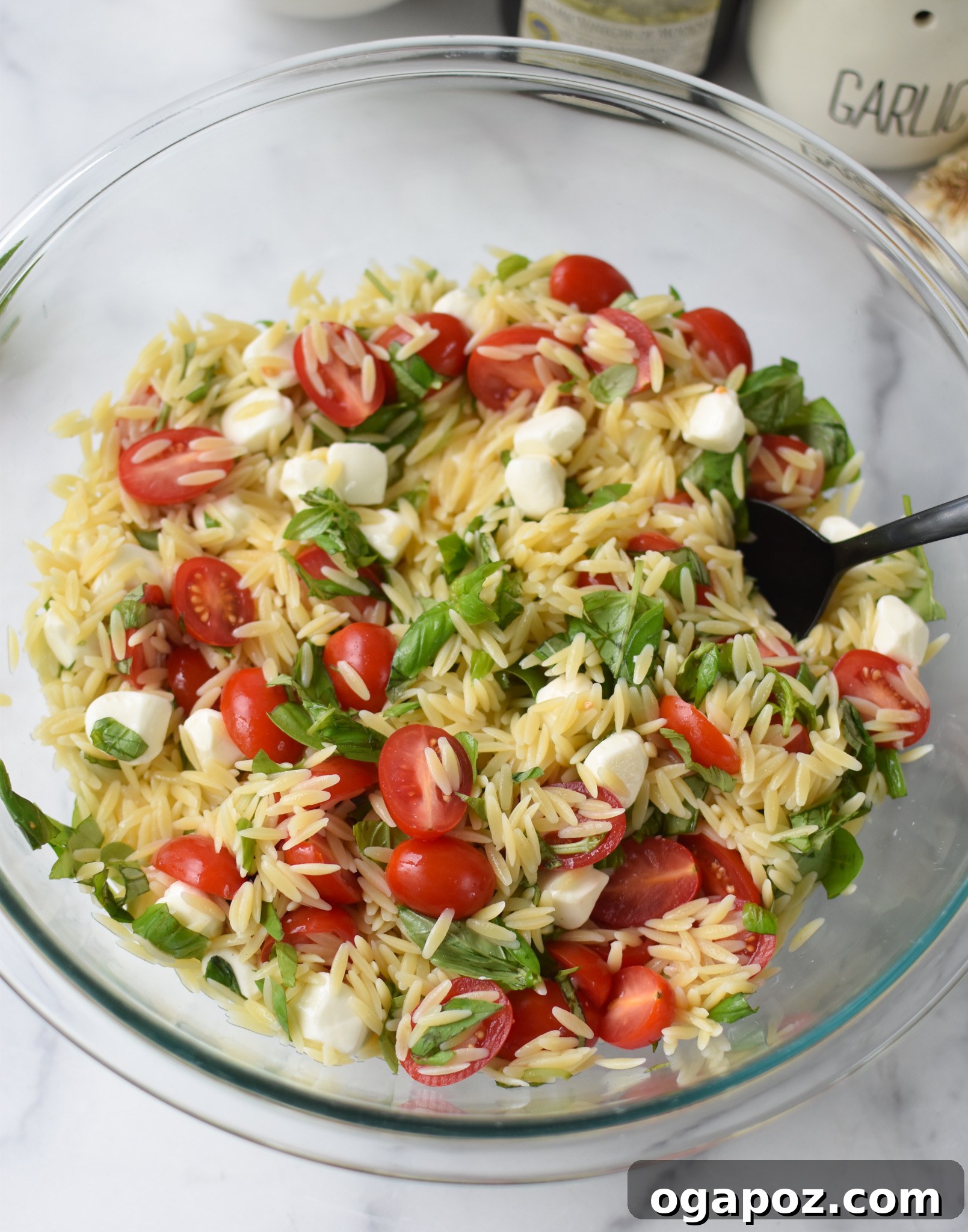 Fresh Caprese Orzo Salad 9 Caprese Orzo Pasta Salad with dressing in glass bowl.