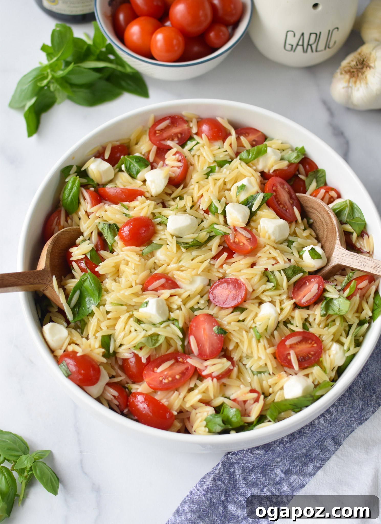Fresh Caprese Orzo Salad 10 Caprese Orzo Pasta Salad with wooden spoons.