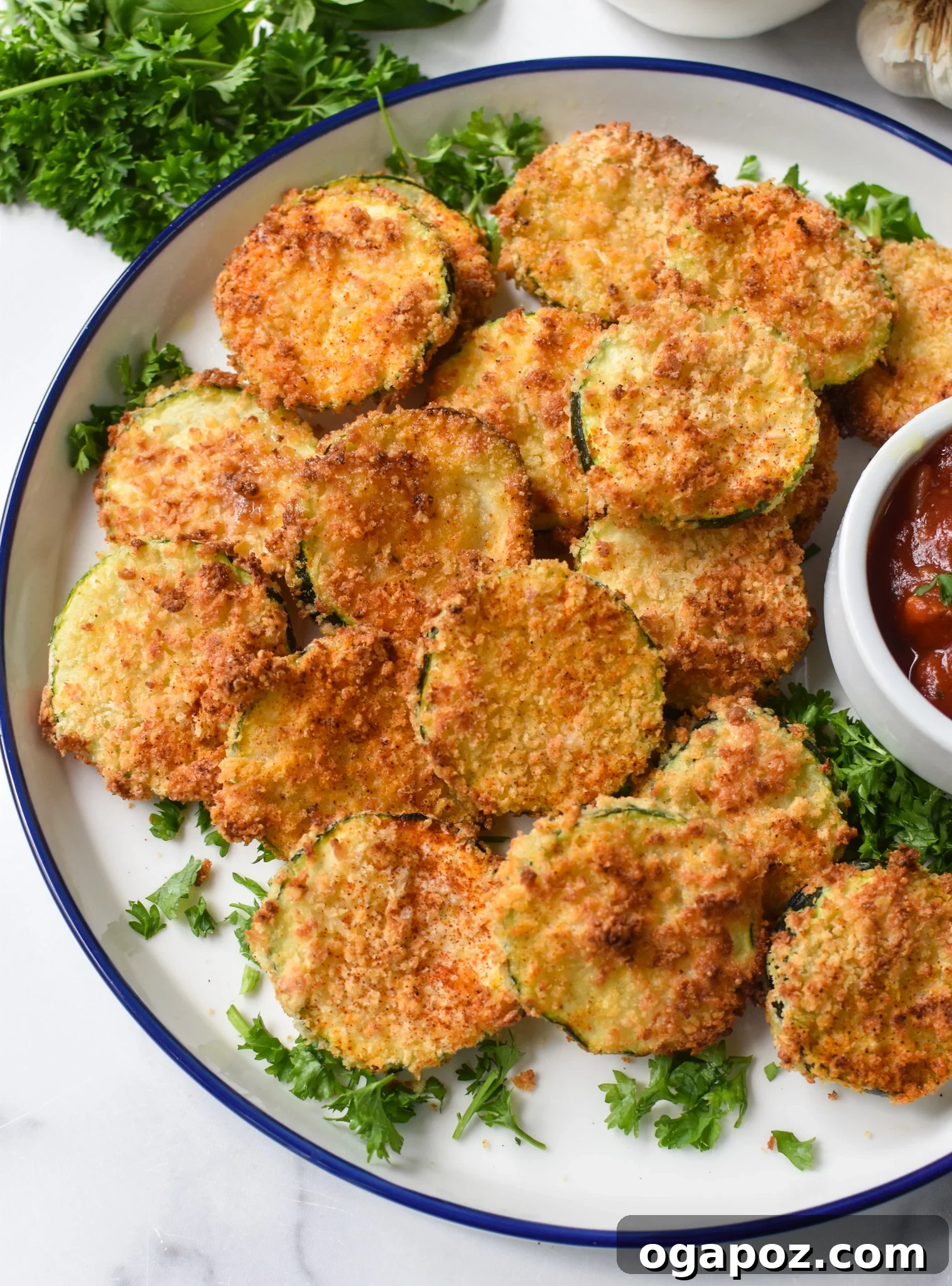 Crispy Air Fryer Zucchini Crisps 7 Air Fryer Zucchini Chips served with marinara sauce in a small dish.
