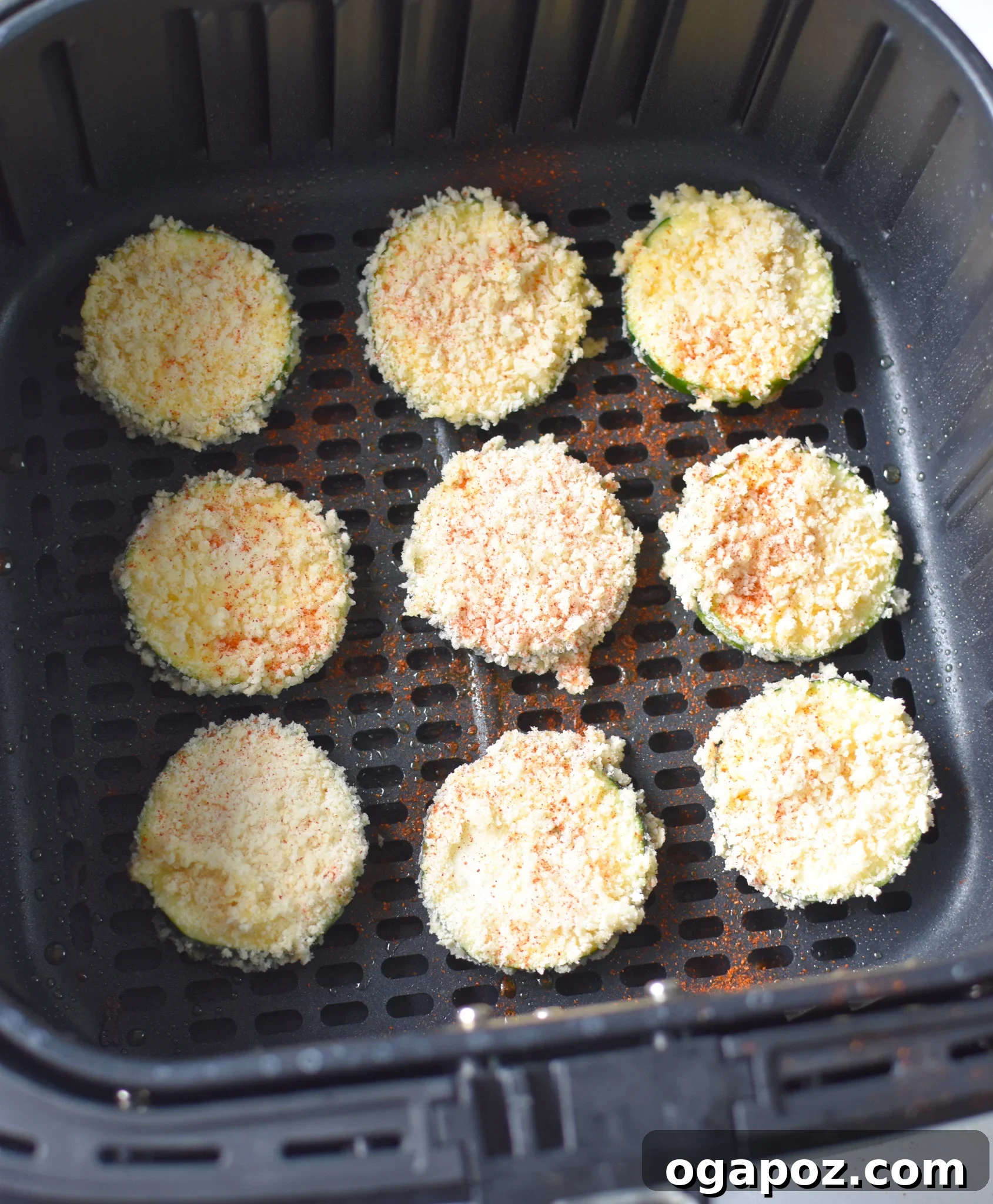 Crispy Air Fryer Zucchini Crisps 10 Air Fryer Zucchini chips cooking inside an air fryer basket.