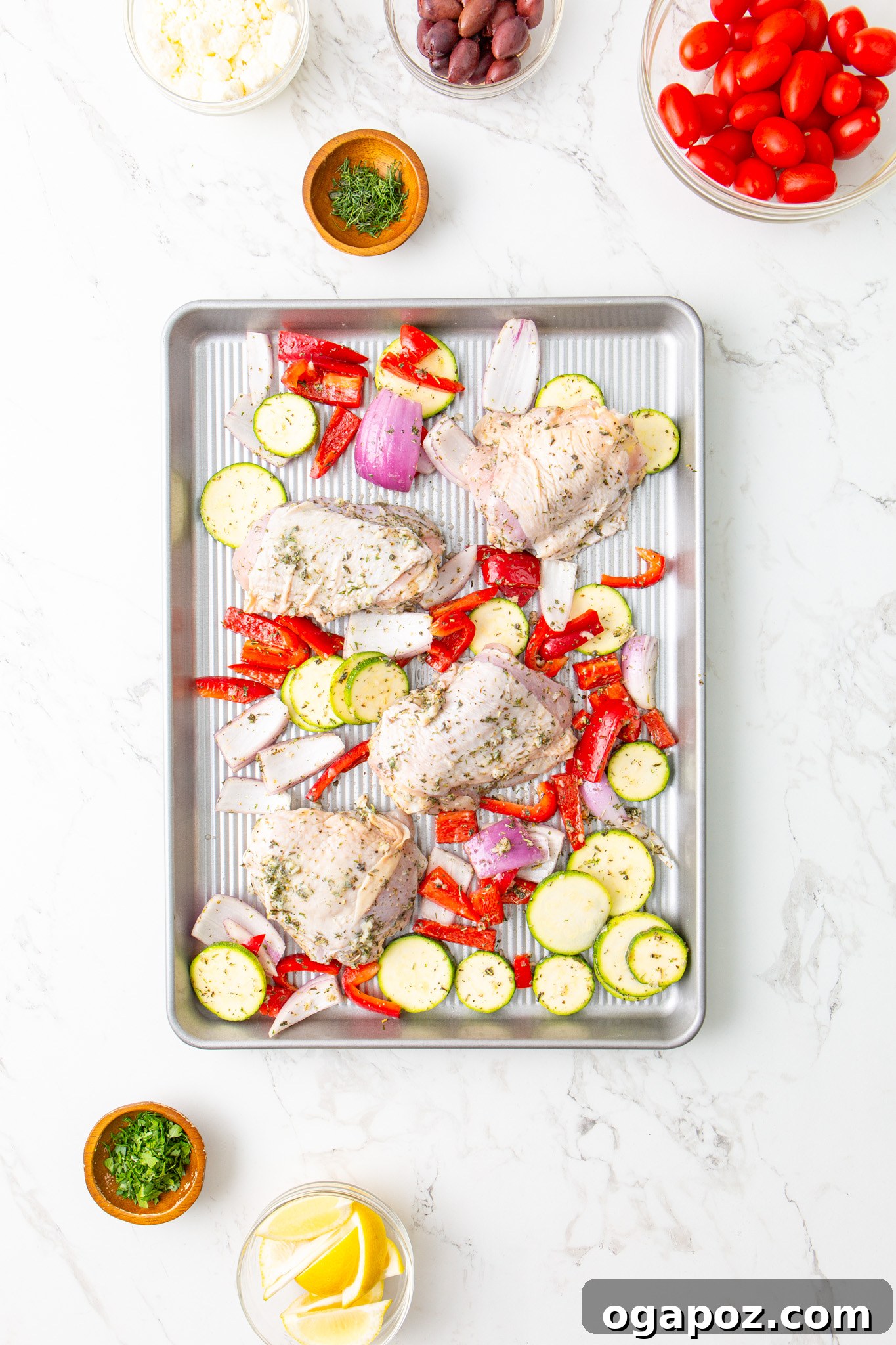 Zesty Mediterranean Sheet Pan Chicken 10 Mediterranean Sheet Pan Chicken arranged on a baking sheet before cooking.