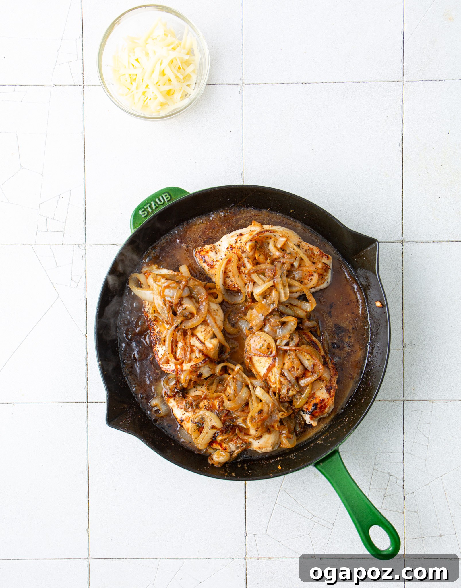French Onion Smothered Chicken 10 Chicken in a skillet with the prepared sauce bubbling gently.