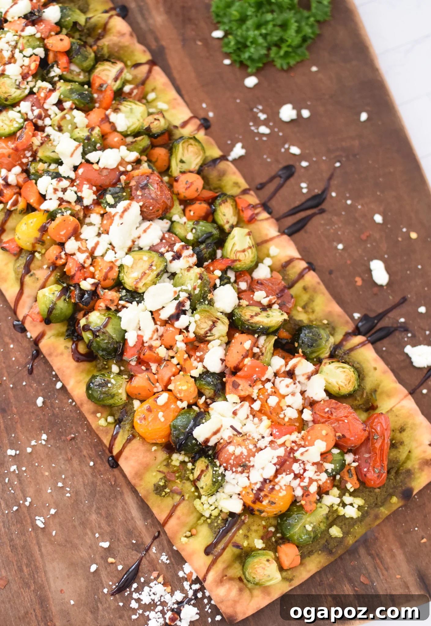 Gourmet Goat Cheese and Roasted Vegetable Flatbread 2 A beautifully arranged Roasted Vegetable Goat Cheese Flatbread Pizza on a wooden cutting board, ready to be served.