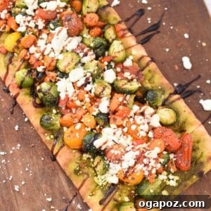 Gourmet Goat Cheese and Roasted Vegetable Flatbread 13 Roasted Vegetable Goat Cheese Flatbread Pizza, garnished and sliced.