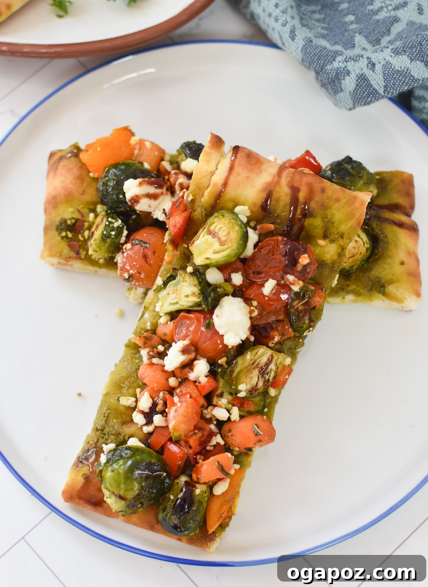 Gourmet Goat Cheese and Roasted Vegetable Flatbread 6 A slice of Roasted Vegetable Goat Cheese Flatbread Pizza served on a clean white plate.
