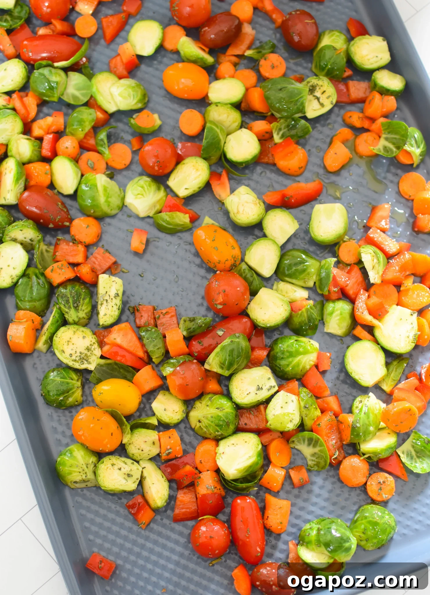 Gourmet Goat Cheese and Roasted Vegetable Flatbread 8 Seasoned bell peppers, carrots, and Brussels sprouts spread evenly on a baking sheet, ready for roasting.
