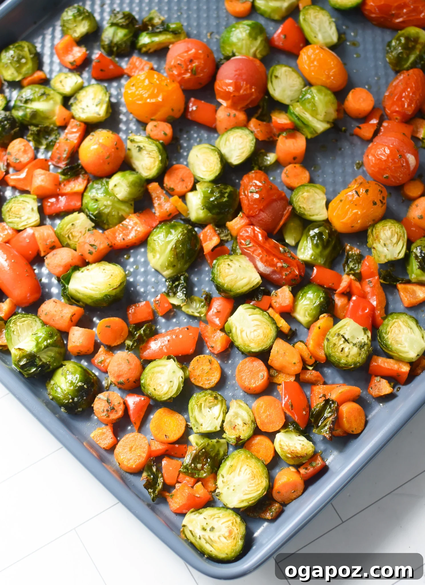 Gourmet Goat Cheese and Roasted Vegetable Flatbread 9 Roasted vegetables including bell peppers, carrots, and Brussels sprouts on a baking sheet, golden and tender.