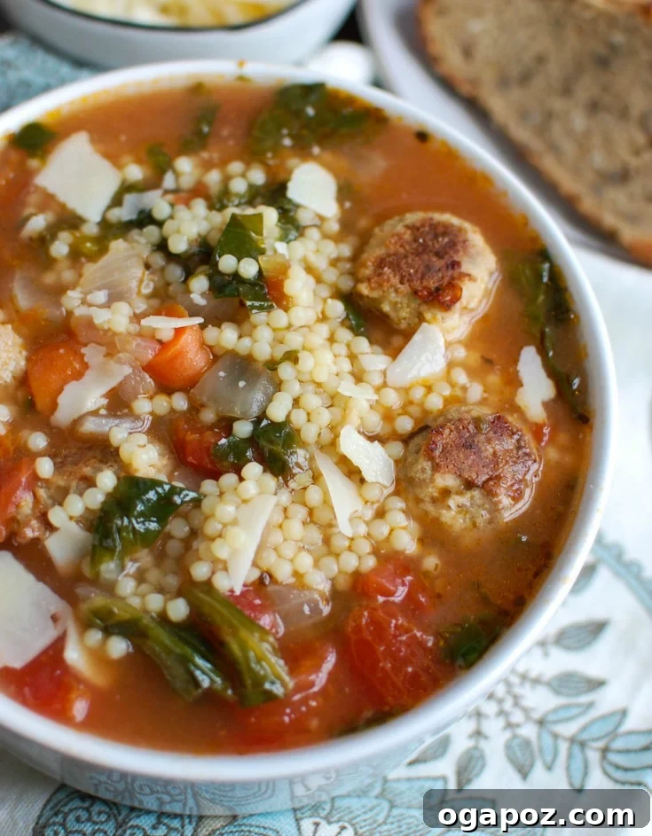Nonna's Italian Wedding Soup 4 A close-up view of a pot of Italian Wedding Soup, highlighting the simmering broth, turkey meatballs, and greens.