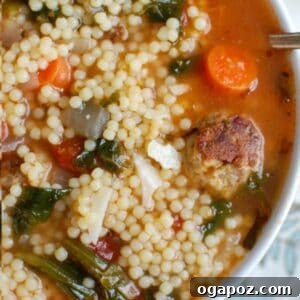 A bowl of Italian Wedding Soup with turkey meatballs, greens, and pasta.