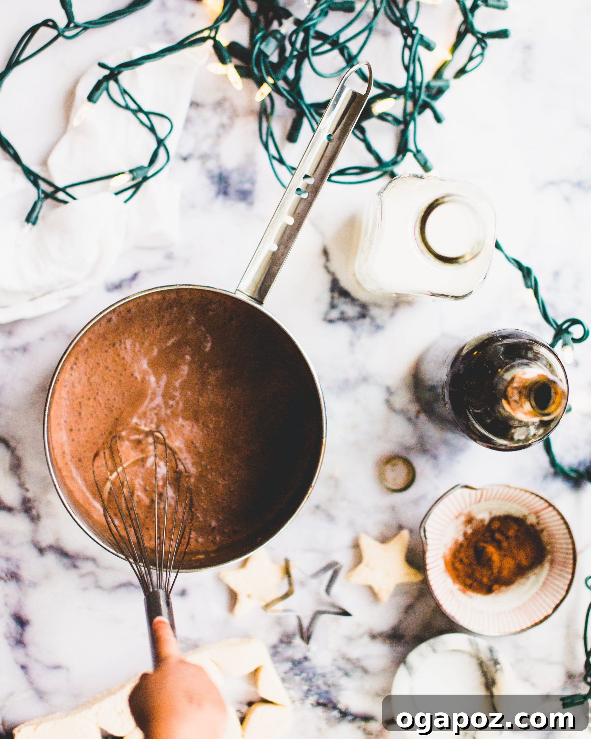 Wholesome Hot Chocolate 3 Ingredients for healthier hot chocolate on a counter, with milk, dates, cocoa, and vanilla