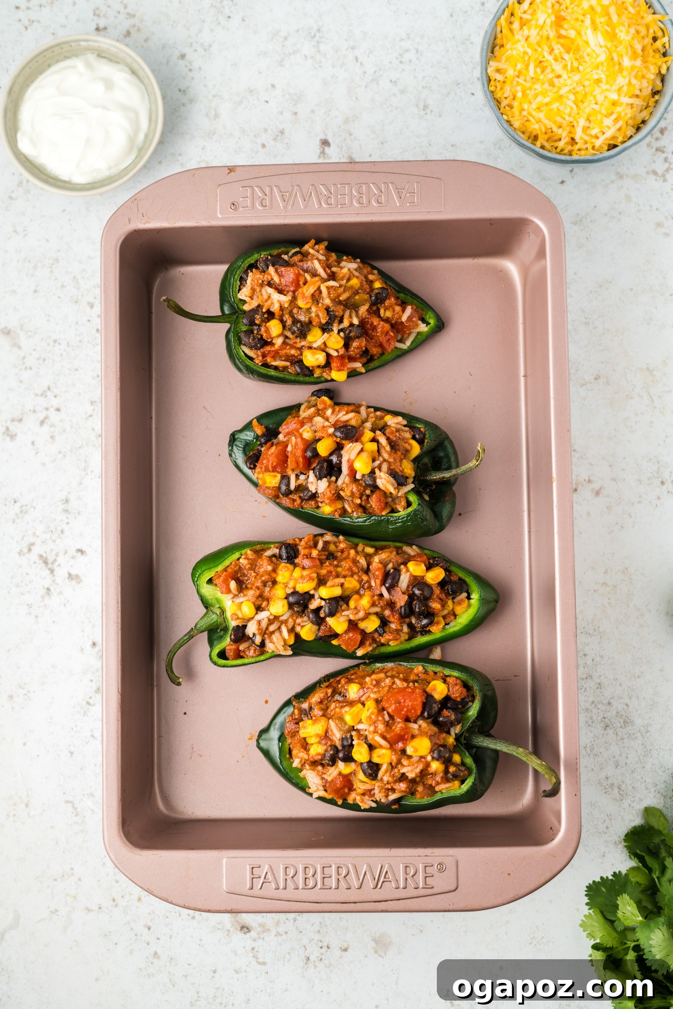 Cheesy Stuffed Poblano Peppers 8 Close-up of stuffed poblano peppers arranged in a baking dish, showing the rich filling neatly packed into the pepper halves before cheese is added.