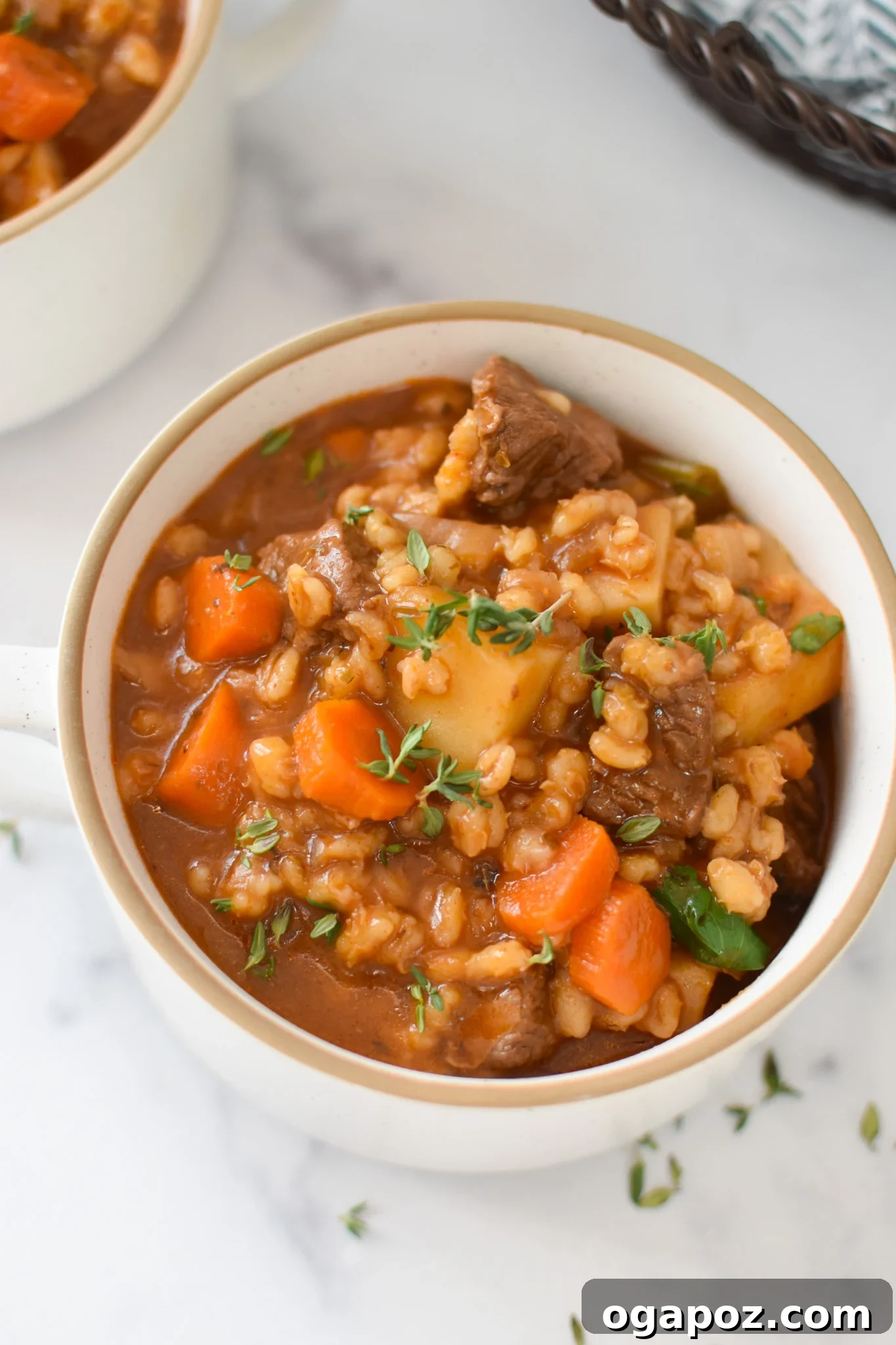Hearty Slow-Simmered Beef Barley Soup 2 Slow Cooker Beef Barley Soup in a white bowl, garnished with fresh herbs
