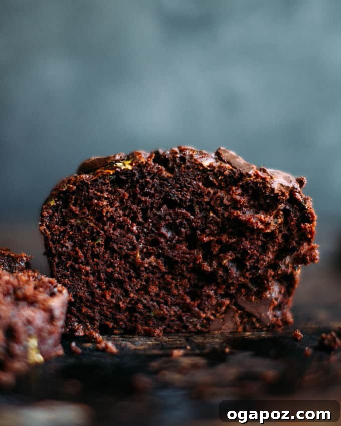 Hidden Veggie Chocolate Bread 2 A freshly baked loaf of chocolate zucchini bread, sliced, on a rustic wooden surface, highlighting its rich color and inviting texture.