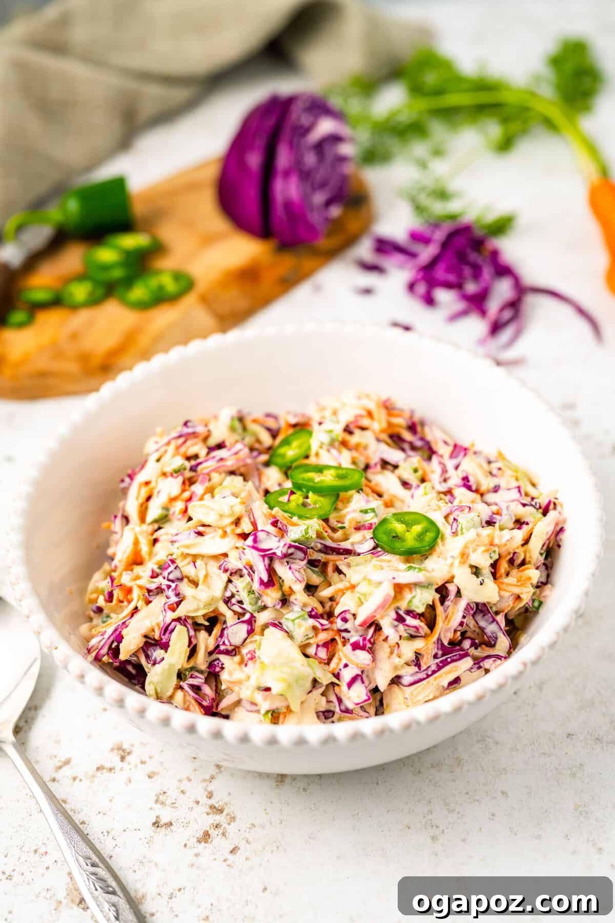 Kickin' Creamy Jalapeno Coleslaw 3 Close-up of fresh Jalapeno Coleslaw in a white bowl, showcasing the vibrant colors of cabbage and carrots.