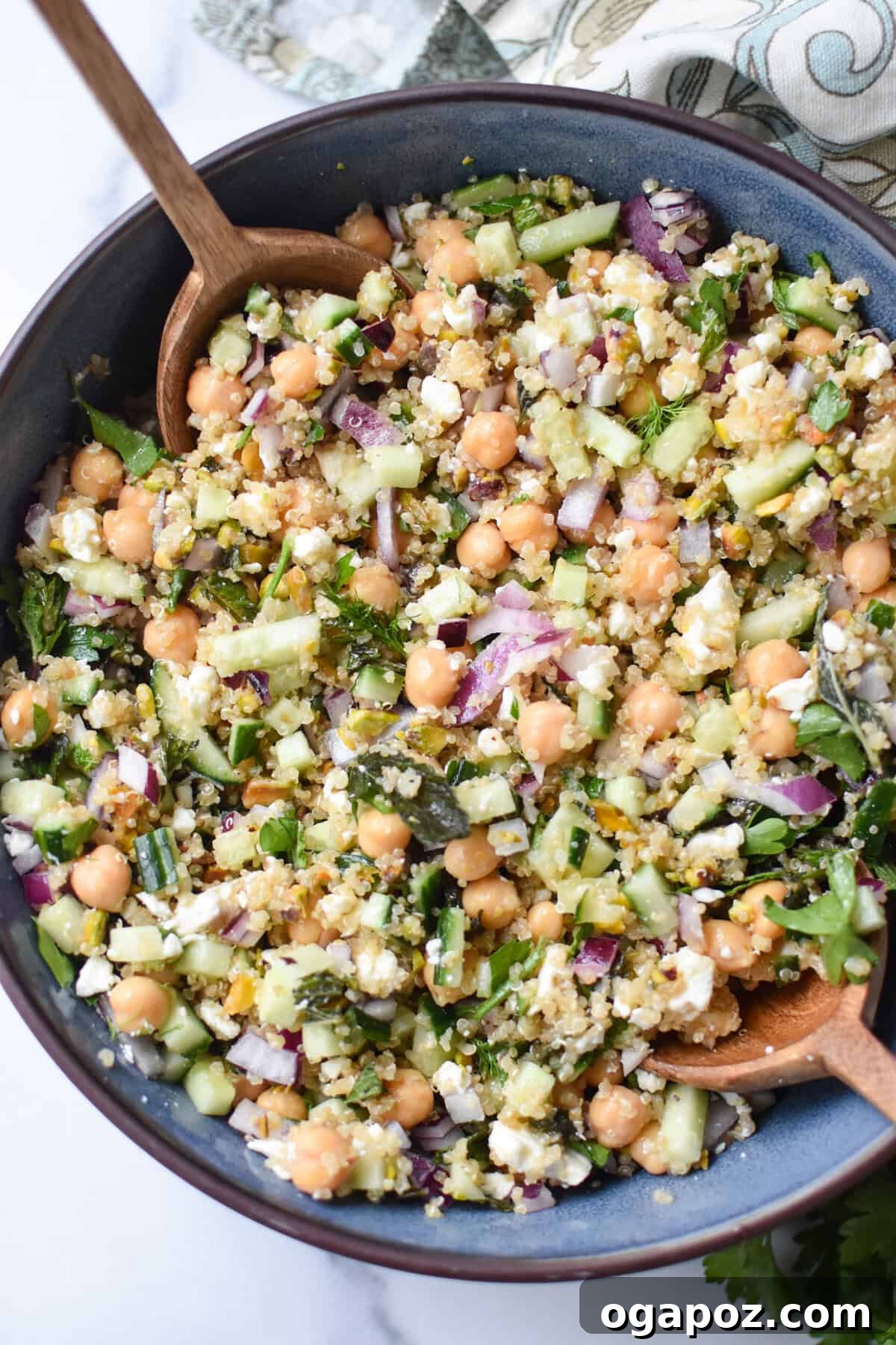 A beautifully mixed Jennifer Aniston Salad in a blue bowl, showcasing its vibrant ingredients like quinoa, chickpeas, and fresh vegetables.