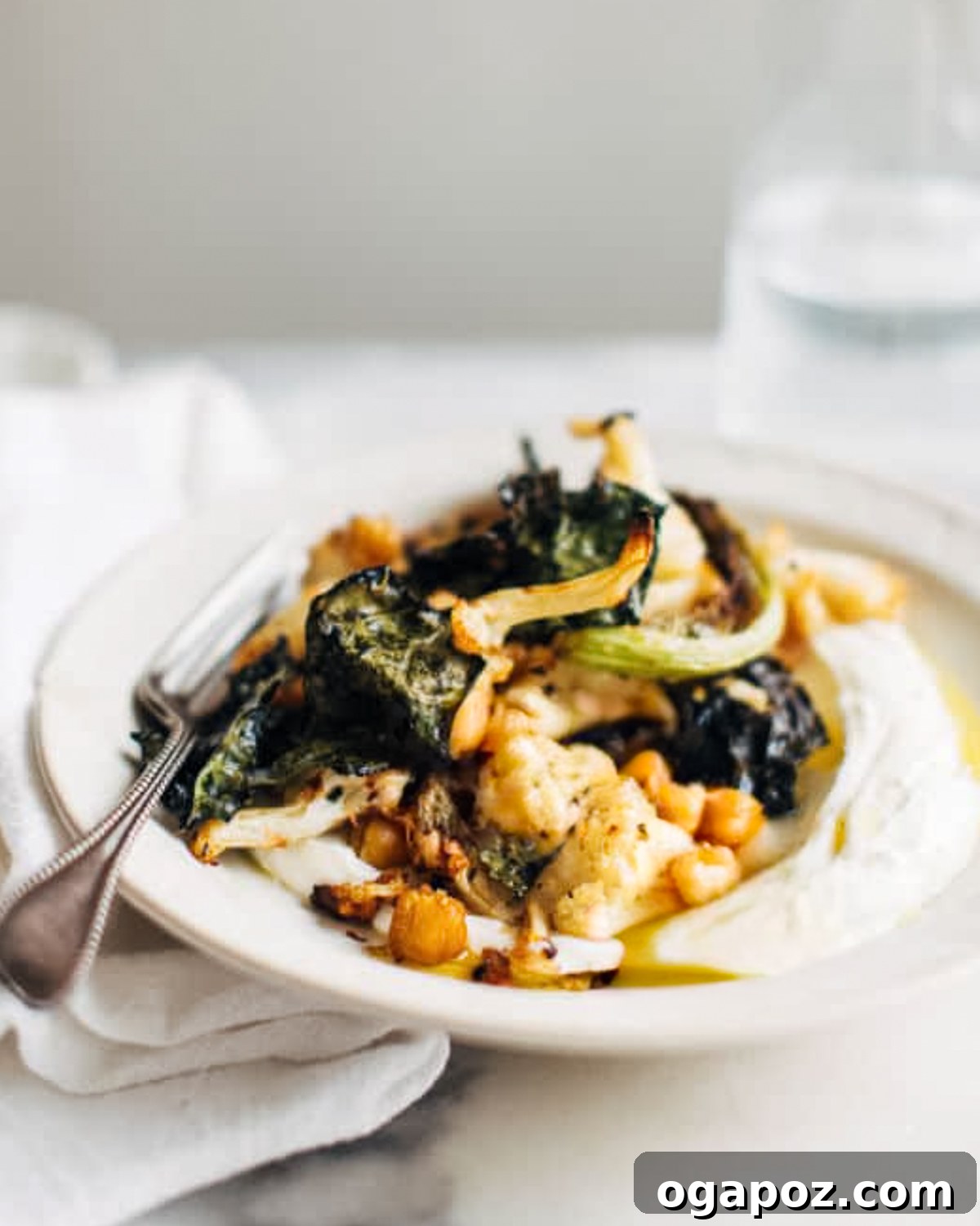 Golden Roasted Cauliflower, Kale & Crispy Chickpea Salad 2 Vibrant Kale, Cauliflower, and Chickpea Salad served on a plate with a fork, ready to be enjoyed.