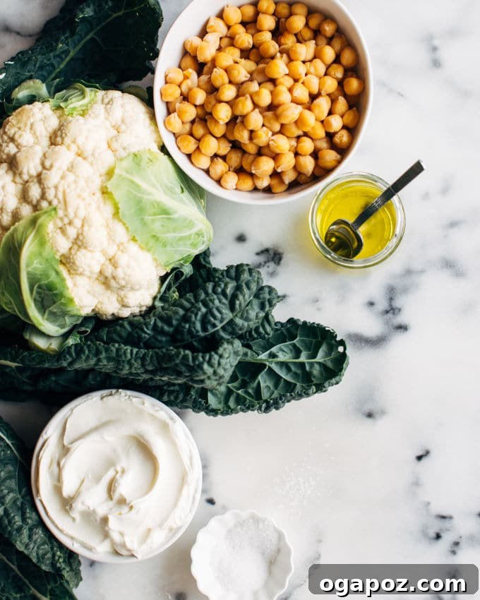 Golden Roasted Cauliflower, Kale & Crispy Chickpea Salad 3 Freshly roasted kale, cauliflower, and chickpeas spread on a baking tray after coming out of the oven.