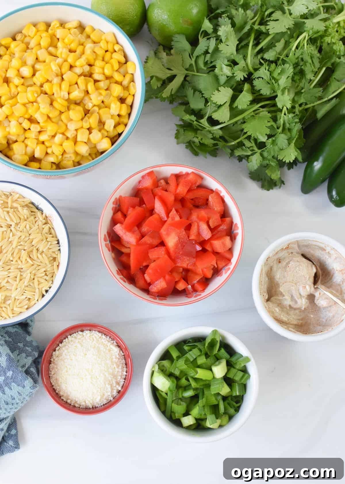 Fiesta Mexican Street Corn Orzo Salad 3 Fresh ingredients for Mexican Street Corn Orzo Pasta Salad laid out on a wooden board