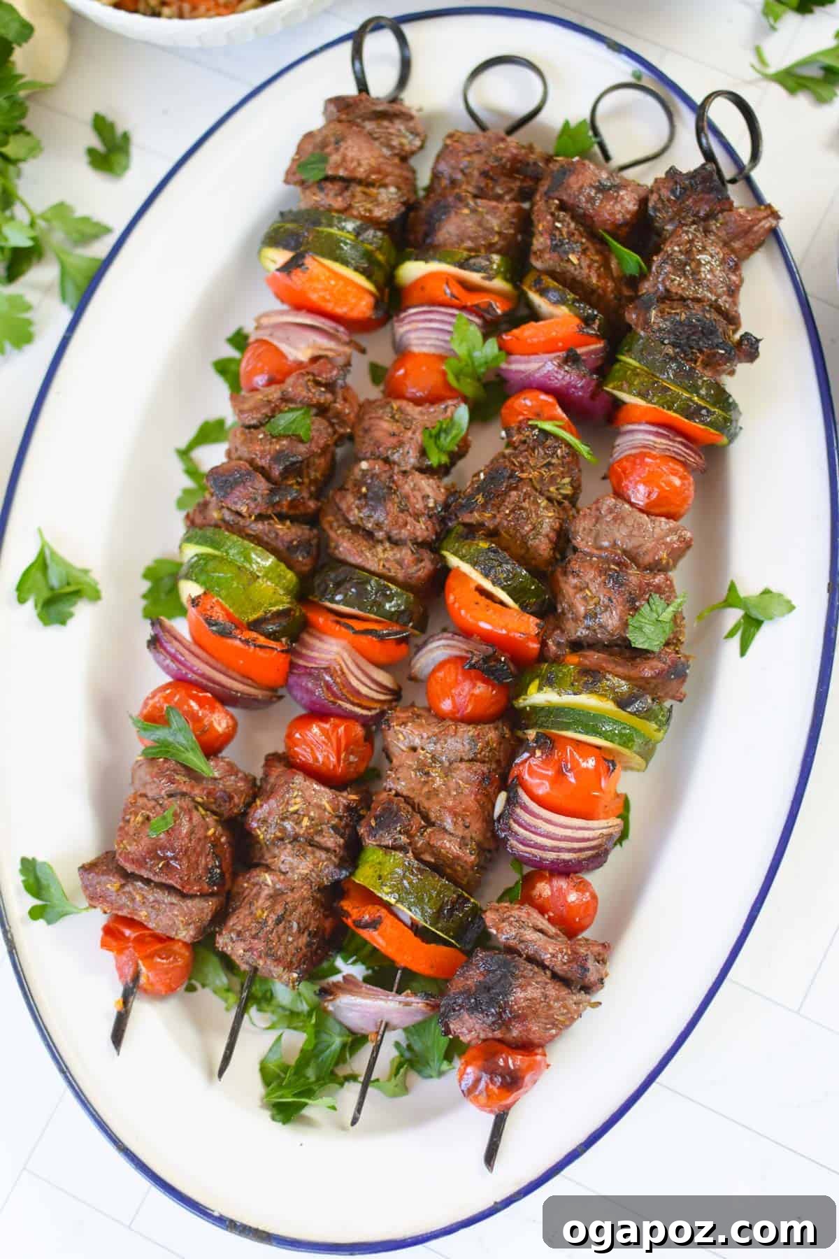 Grilled Beef Souvlaki Skewers 12 Plated Beef Souvlaki with a side of tzatziki on a white platter.