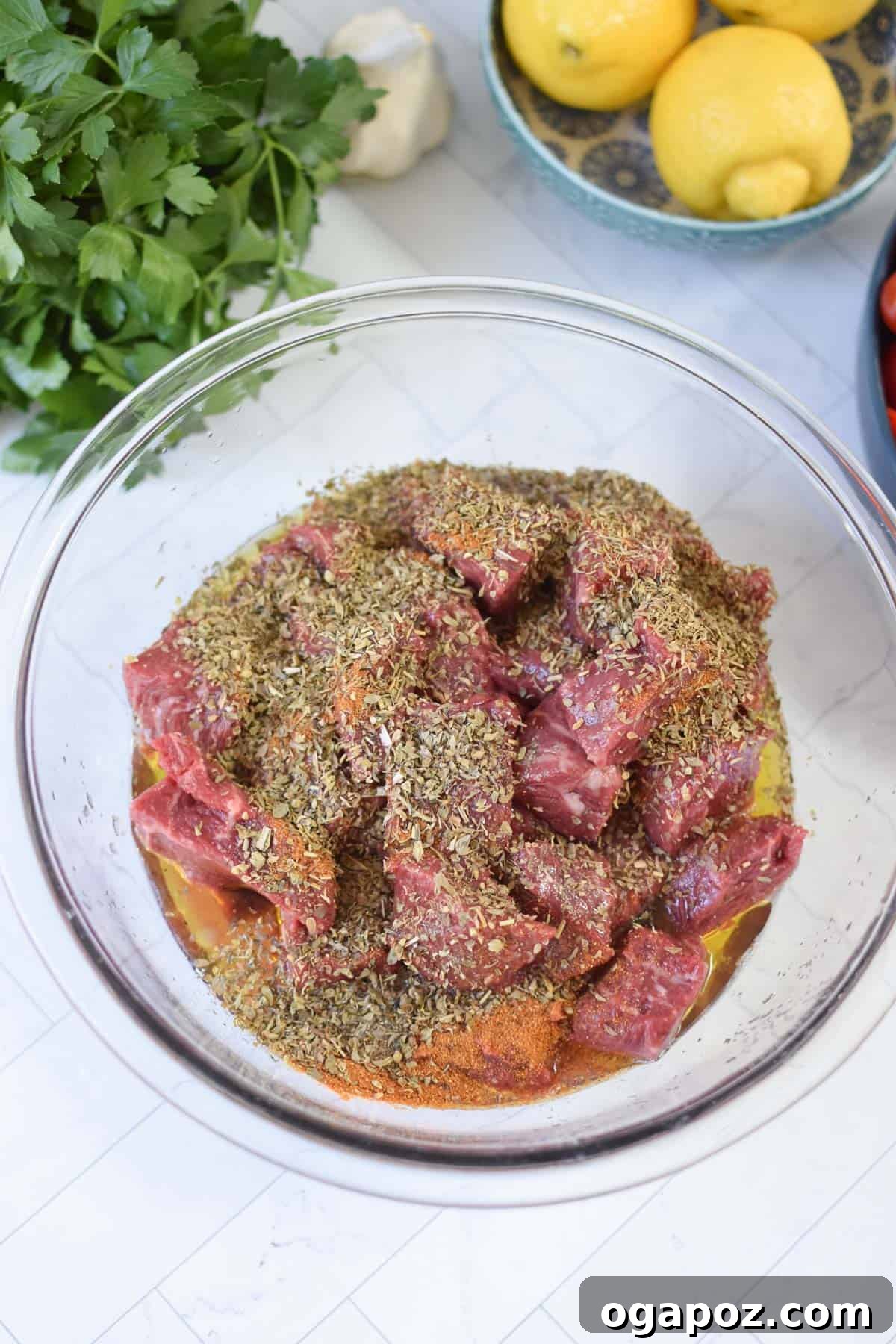 Grilled Beef Souvlaki Skewers 8 Beef Souvlaki beef cubes marinating in a glass bowl.