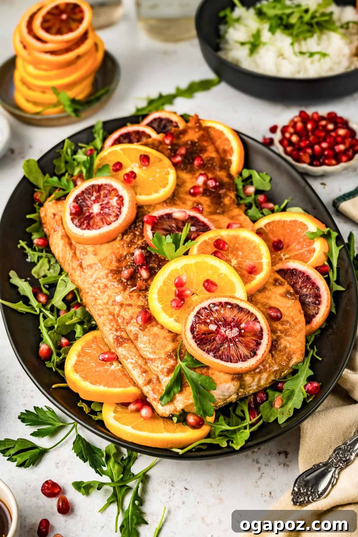Zesty Orange Glazed Salmon 10 Orange Glazed Salmon served elegantly on a black plate with fresh garnishes.