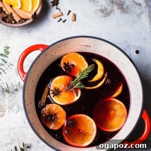 Zesty Winter Warmer 6 Spiced Citrus Mulled Wine Recipe in a pot with orange slices and rosemary.