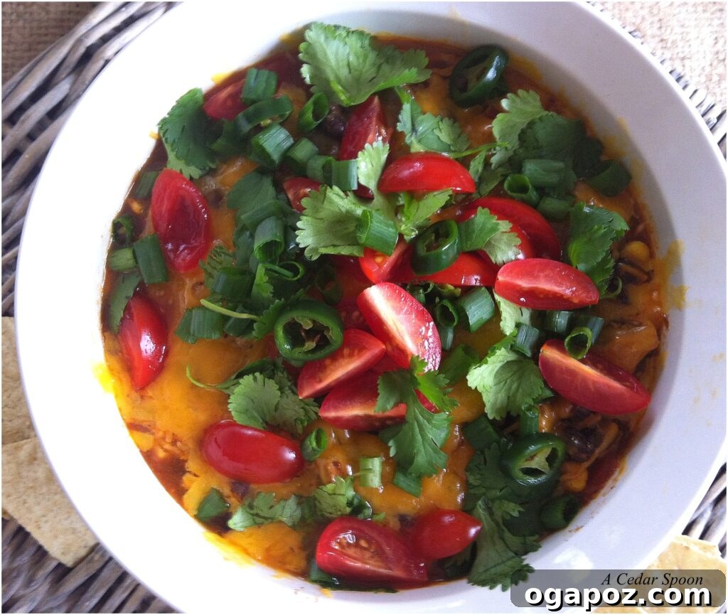 Smoky Oven-Baked Black Bean Dip 4 Baked Black Bean Dip in a white serving bowl with fresh cilantro garnish