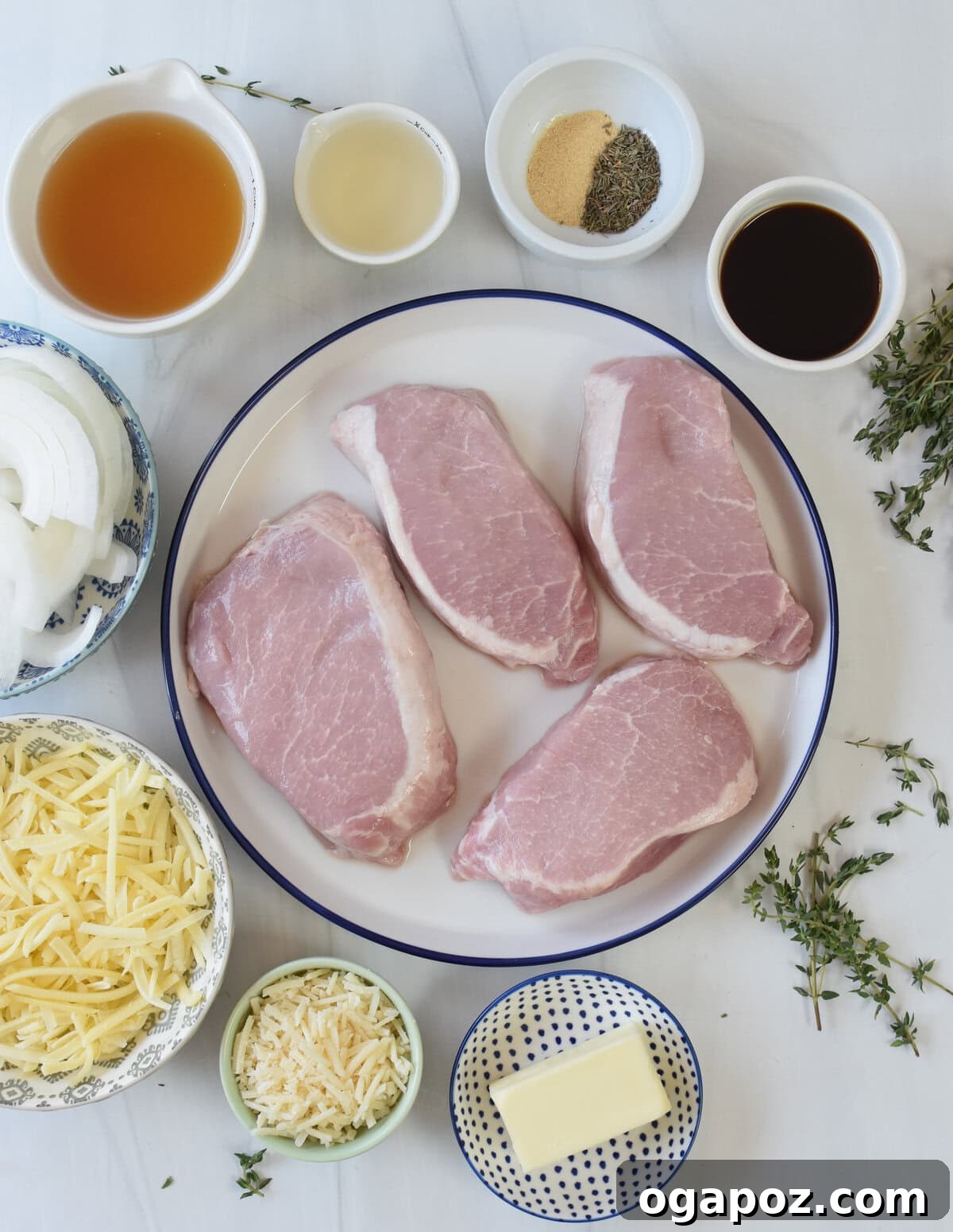 Fresh ingredients laid out for French Onion Pork Chops, including sliced onions, pork chops, wine, and cheese.