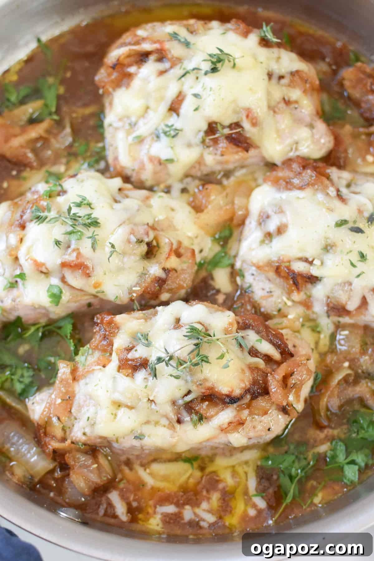 Close-up of French Onion Pork Chops garnished with vibrant fresh thyme, ready to be served.