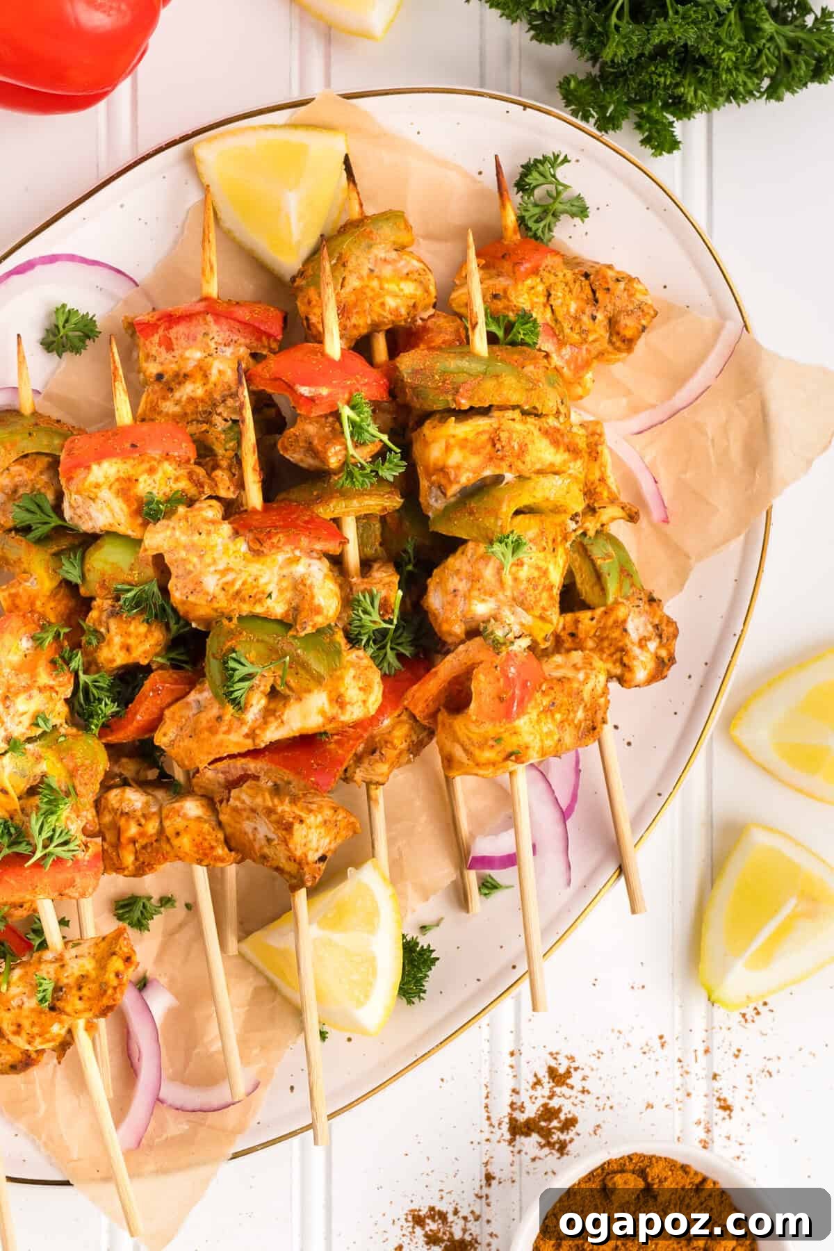 Zesty Grilled Chicken Tikka Skewers 2 Tender and flavorful Chicken Tikka Kebabs on a white plate, garnished with fresh herbs