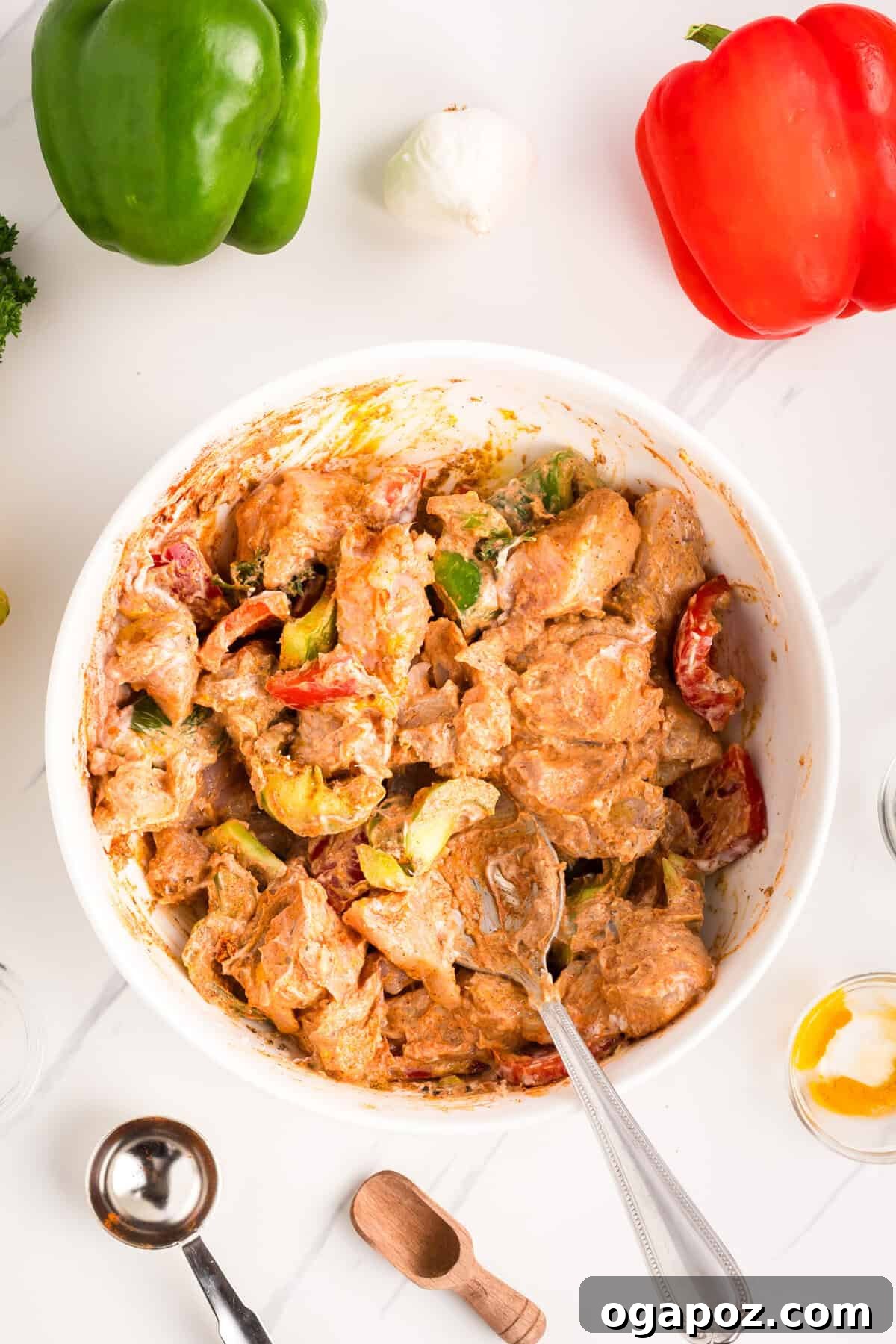 Zesty Grilled Chicken Tikka Skewers 8 A bowl of chicken marinating in the refrigerator, covered with plastic wrap