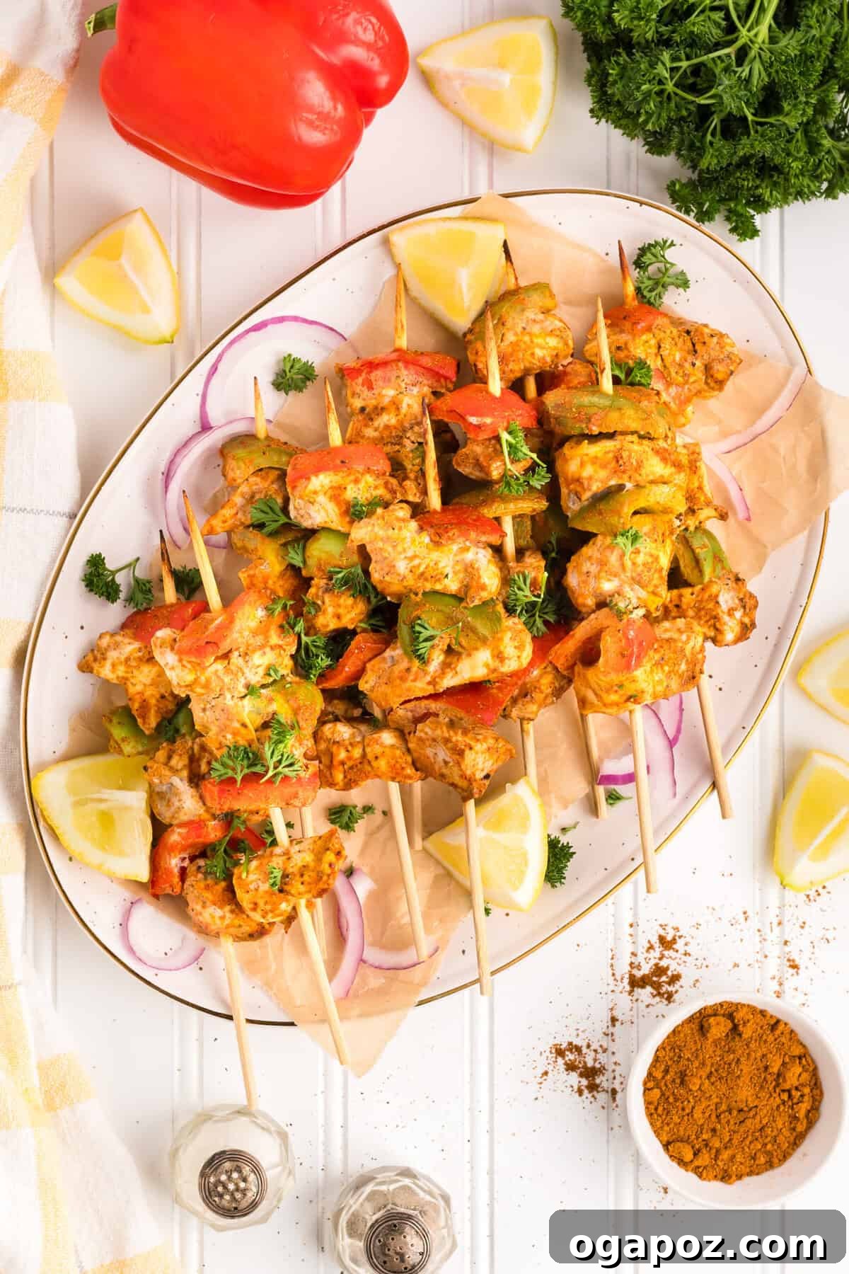 Zesty Grilled Chicken Tikka Skewers 10 Delicious baked Chicken Tikka Kebabs served on a pristine white plate, garnished