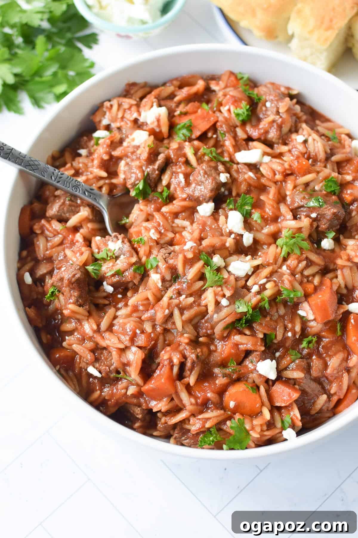 Hearty Greek Giouvetsi Beef Orzo Stew 7 Greek Beef Stew with Orzo served in a white bowl with fresh parsley