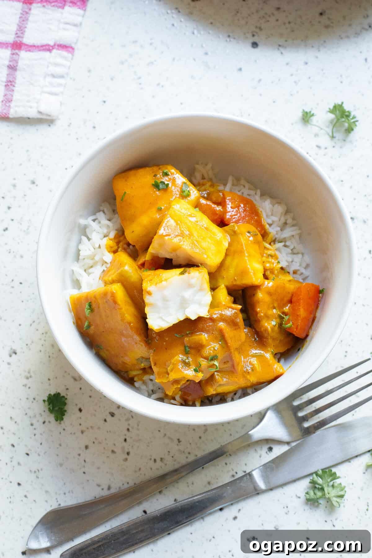 A serving of Coconut Fish Curry in a rustic bowl, garnished with fresh cilantro, ready to be enjoyed with rice.